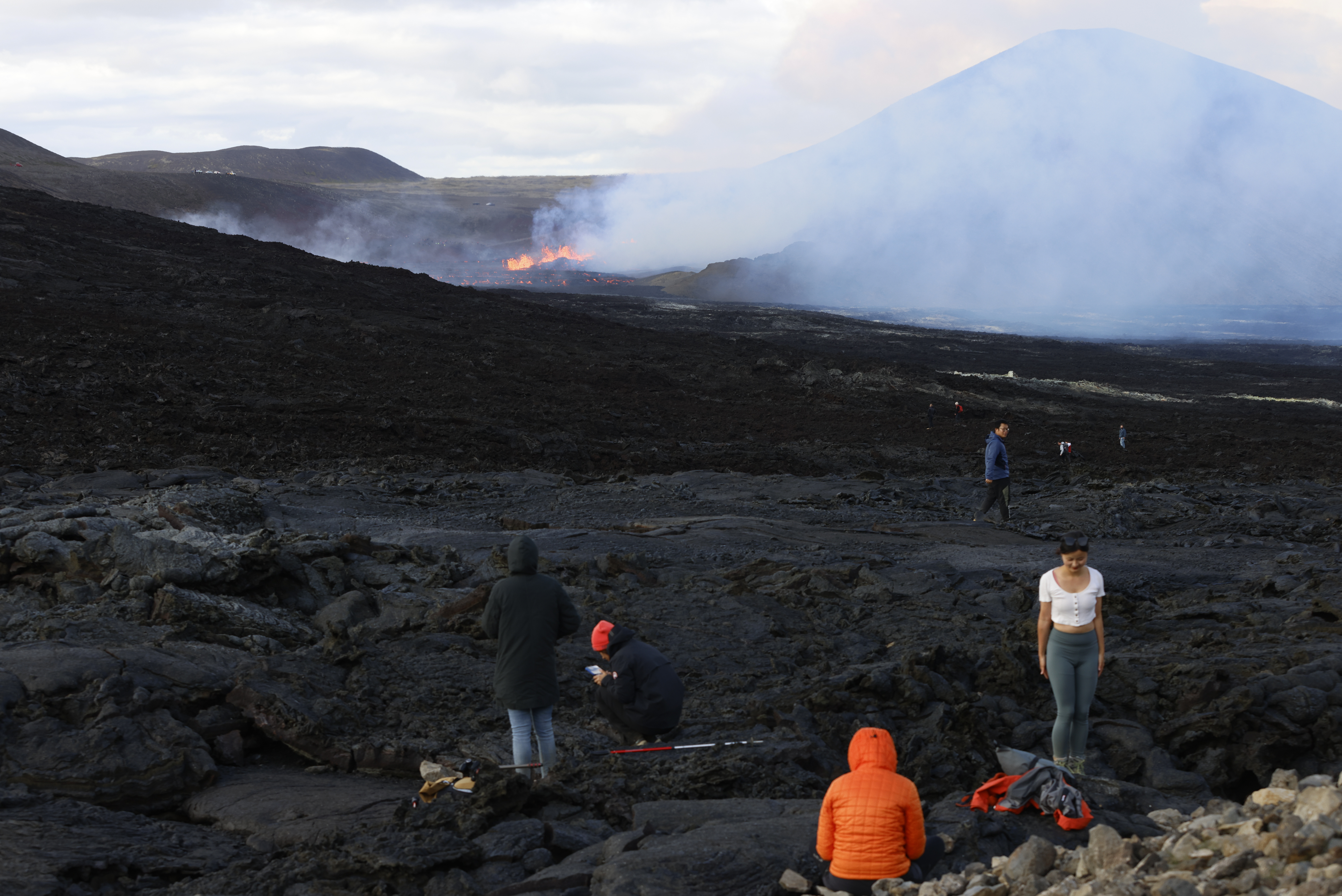 People walk to get a view of the eruptions on Fagradalsfjall volcano