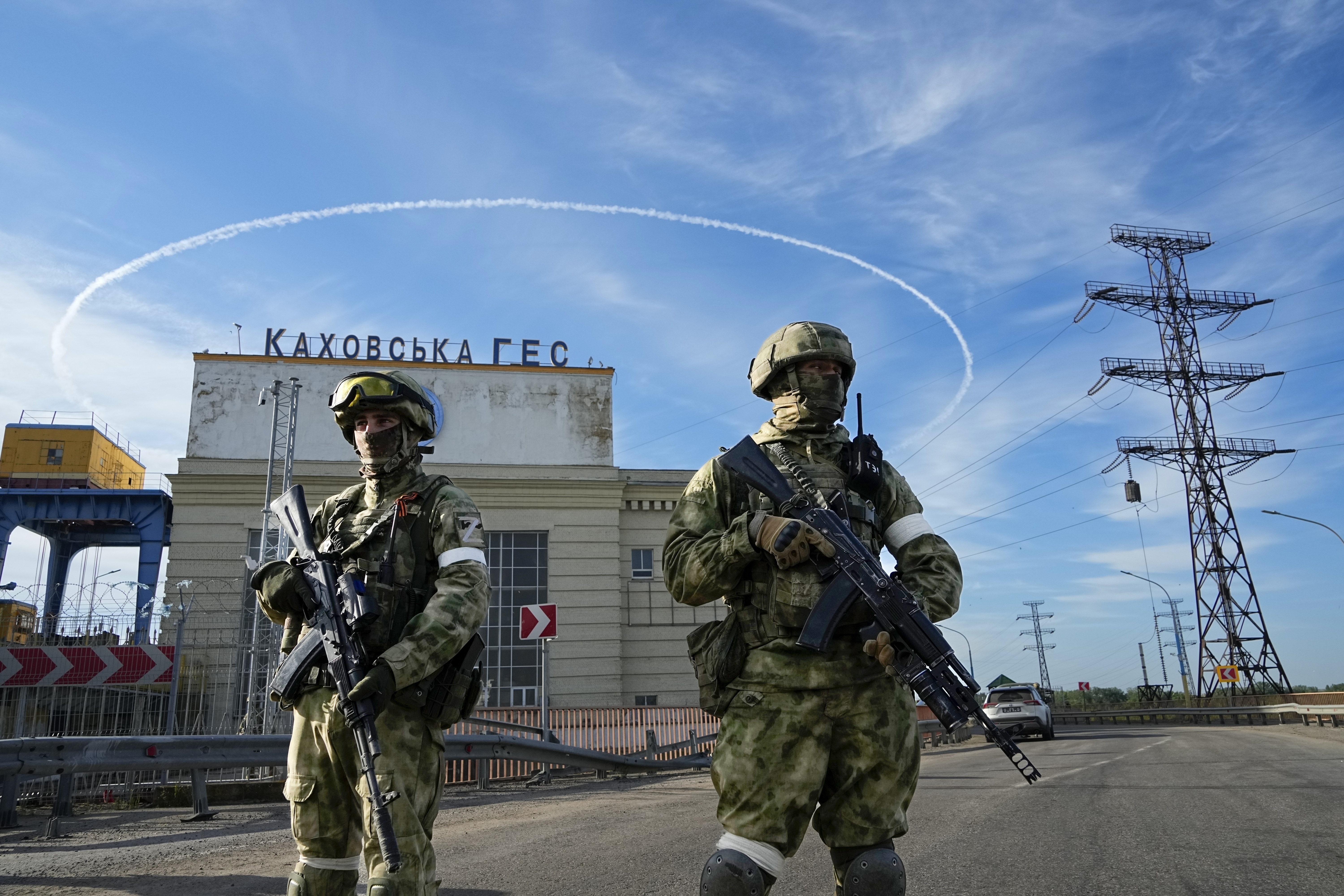 Russian troops guard an entrance of the Kakhovka Hydroelectric Station, a run-of-the-river power plant on the Dnieper River in Kherson region, southern Ukraine