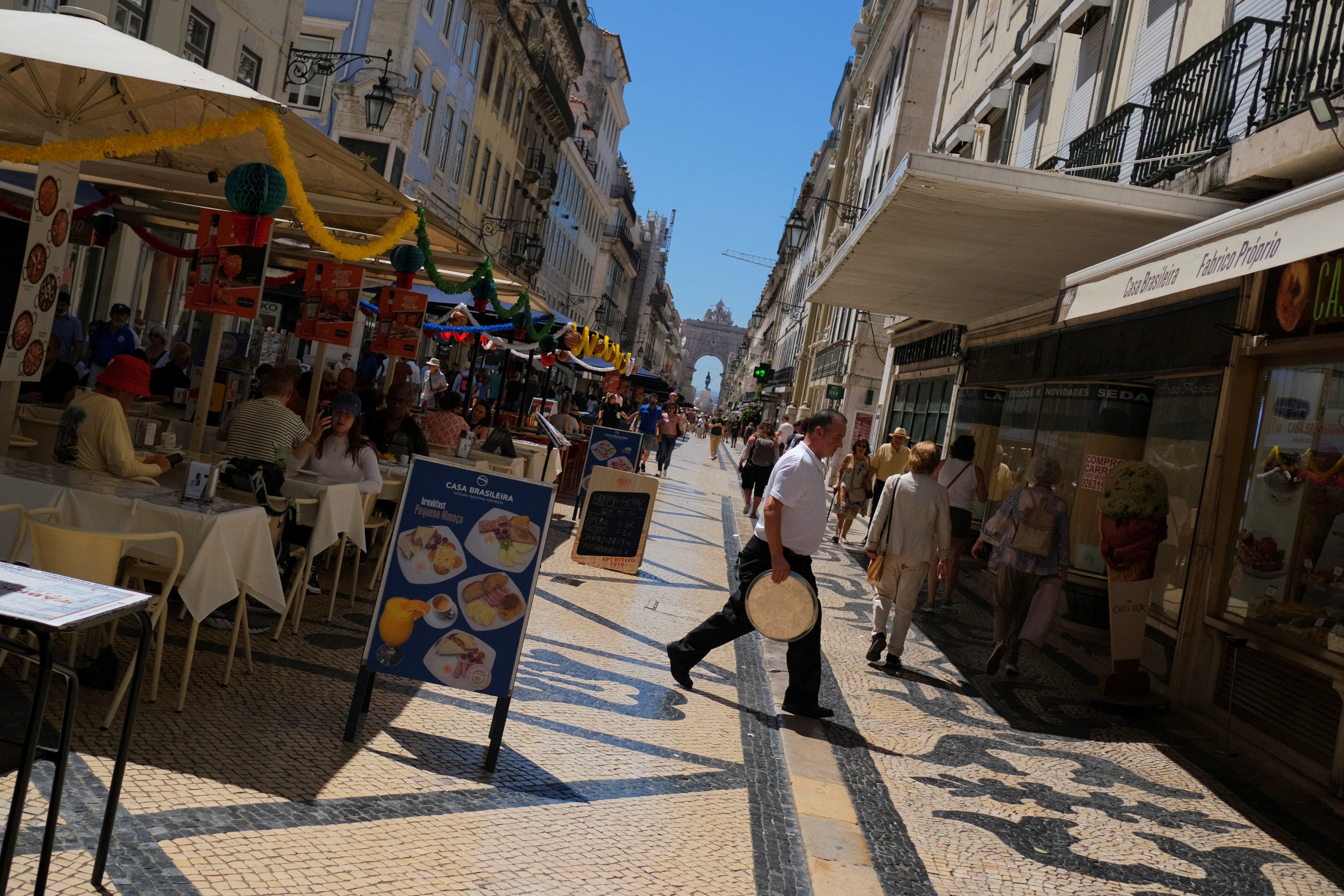 A waiter walks holding a tray in a restaurant in Lisbon, Portugal