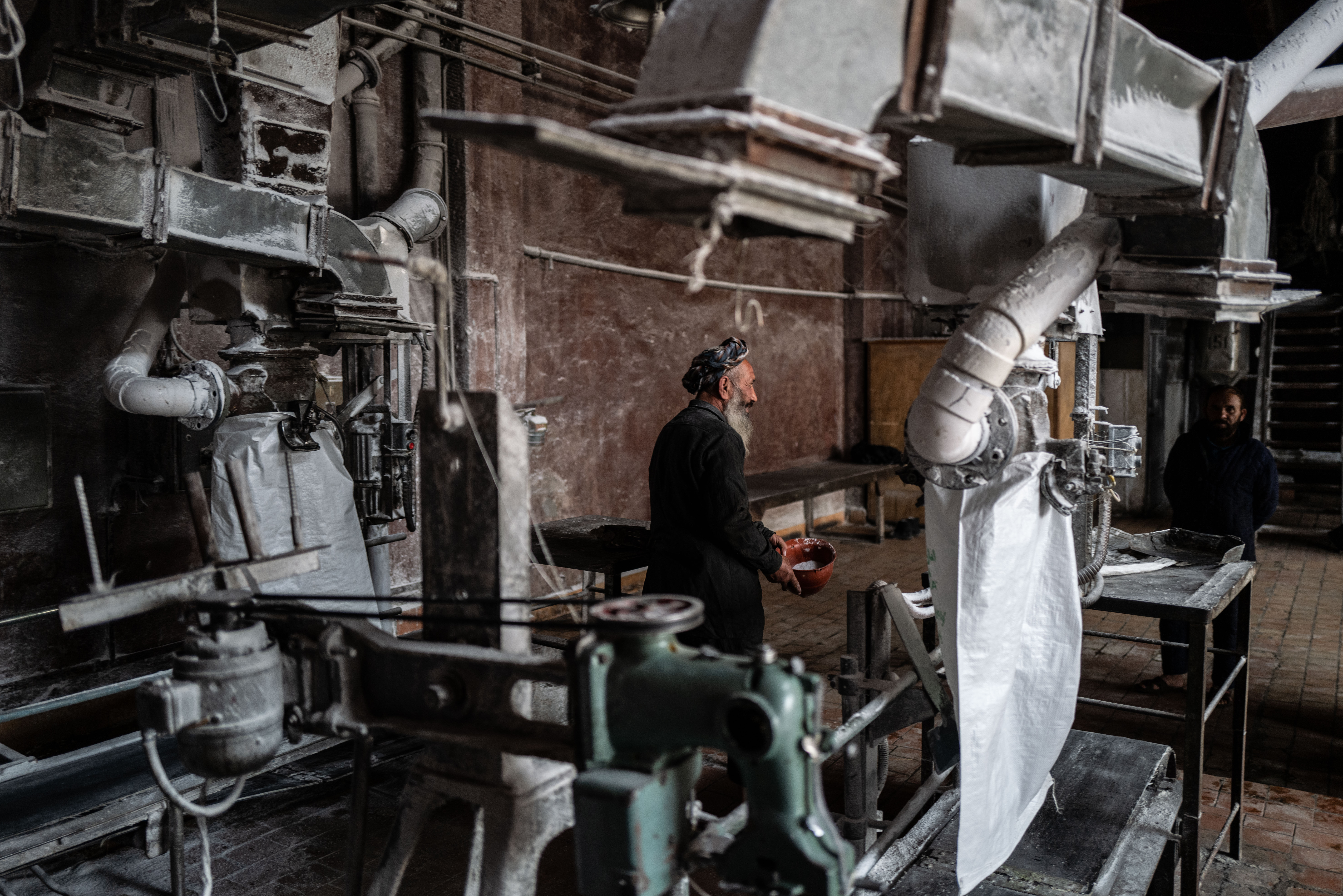 A photo of a man filling bags of of urea.