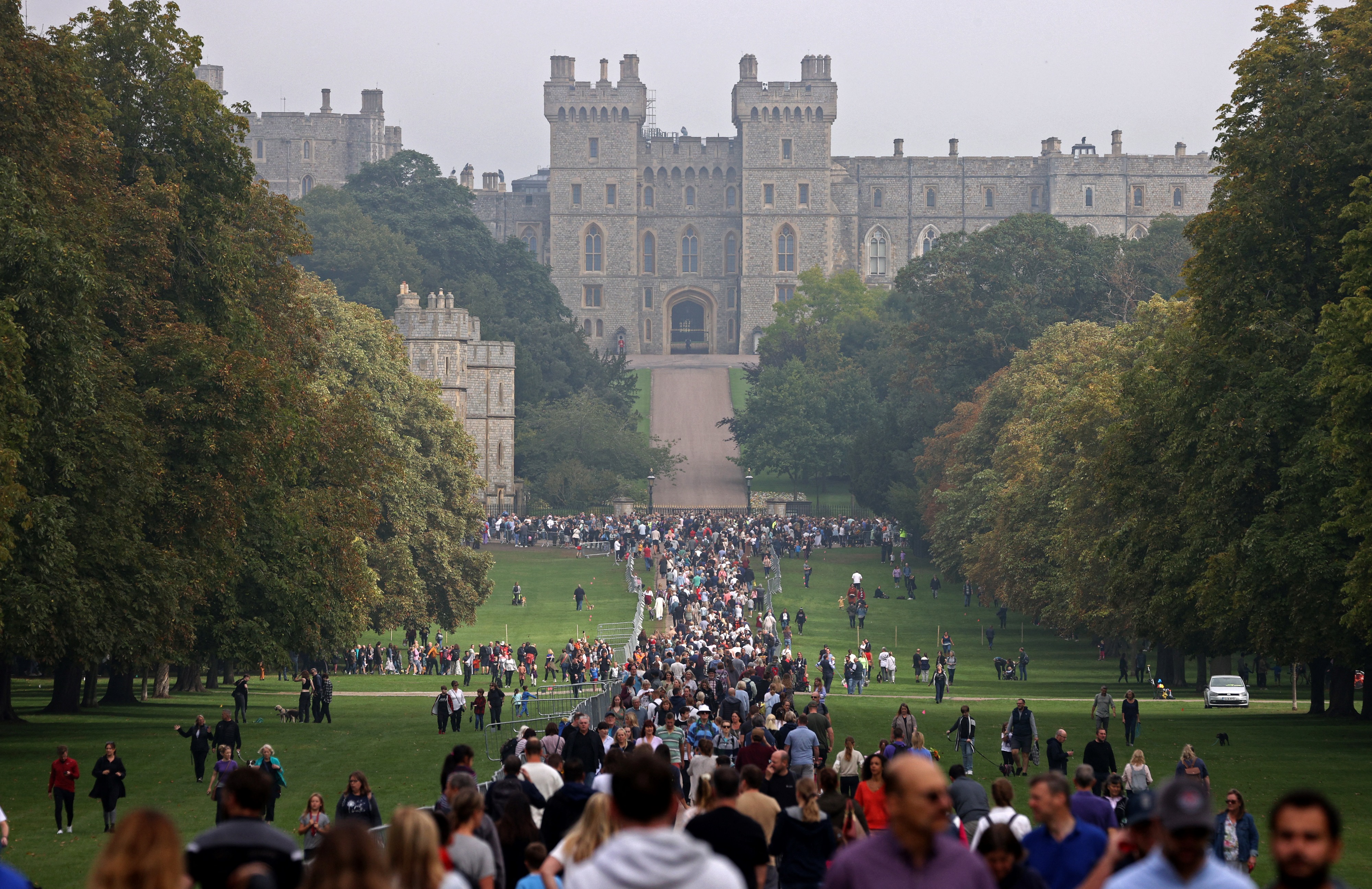 Members of the public walk along the Long Walk in Windsor Great Park, outside of Windsor Castle, west of London [File: Adrian Dennis/AFP]