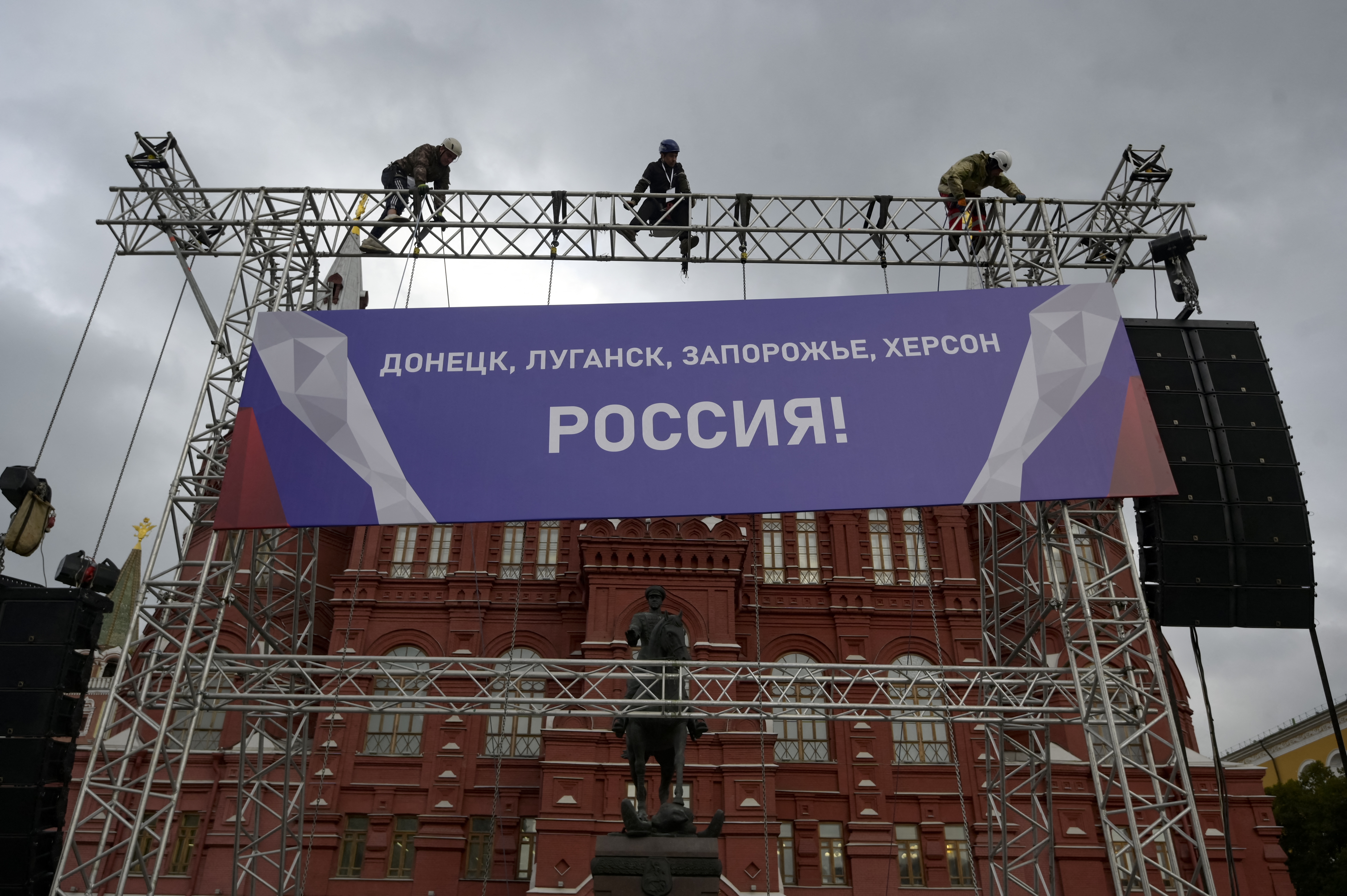Workers fix a banner reading "Donetsk, Lugansk, Zaporizhzhia, Kherson - Russia!" in the Red Square in central Moscow.