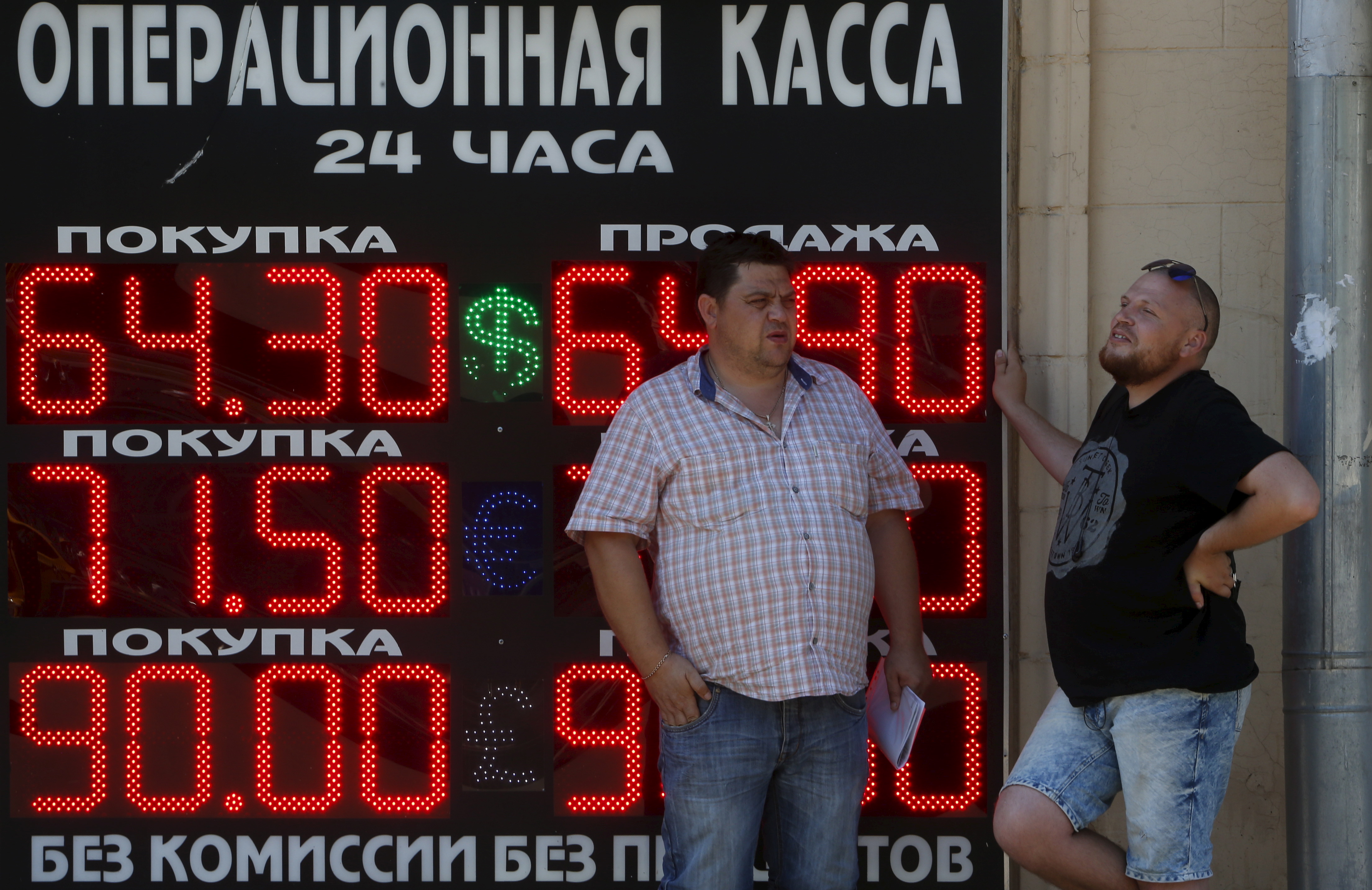 Men stand next to a board showing currency exchange rates of the U.S. dollar, euro, and British pound (top-bottom) against the rouble in Moscow, Russia, August 12, 2015. The Russian rouble hit a six-month low on Wednesday, tracking down lower oil prices and ignoring a central bank statement saying that the devaluation of the Chinese yuan may ultimately benefit the rouble. REUTERS/Sergei Karpukhin