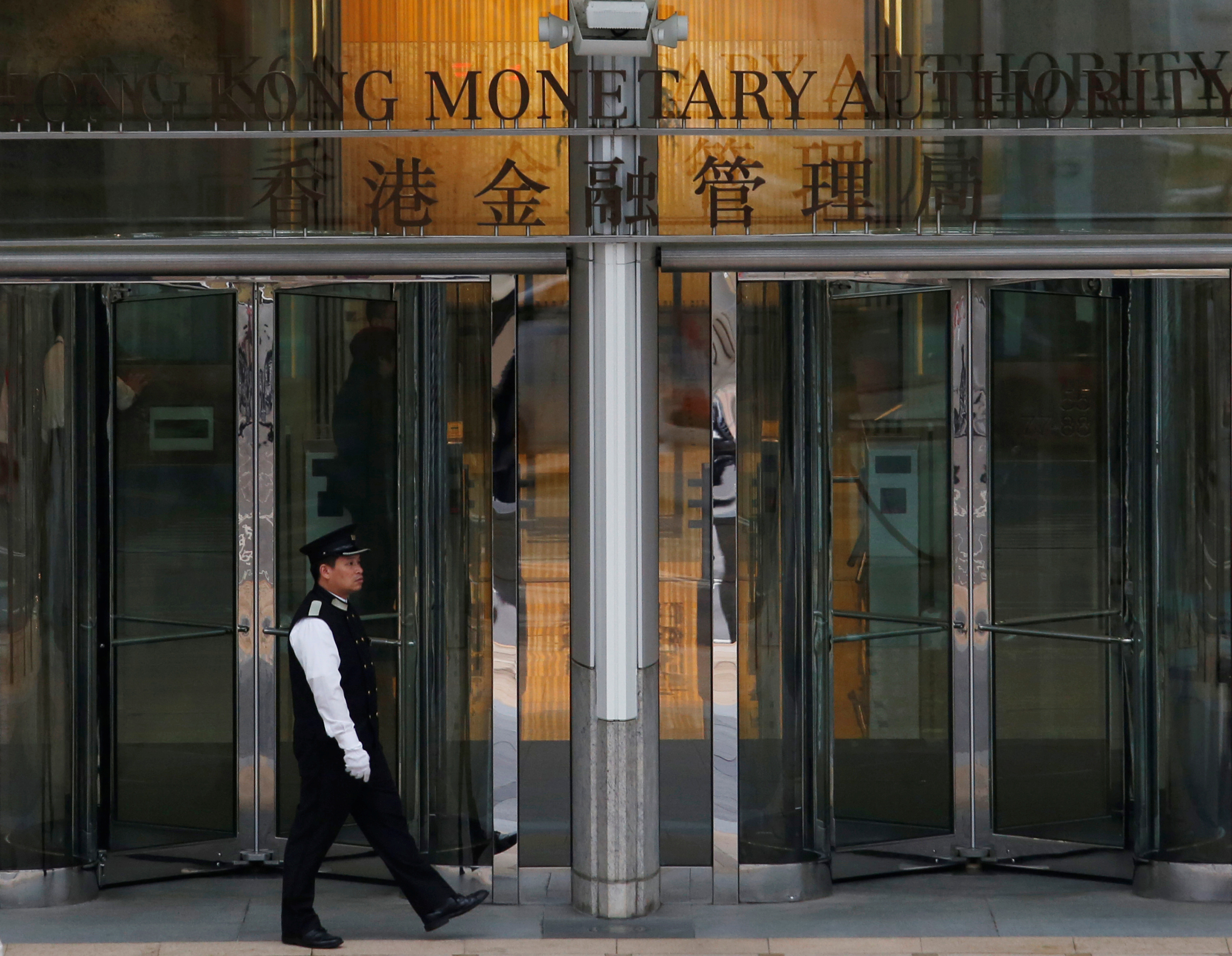 An attendant walks outside the entrance to Hong Kong Monetary Authority in Hong Kong, China.