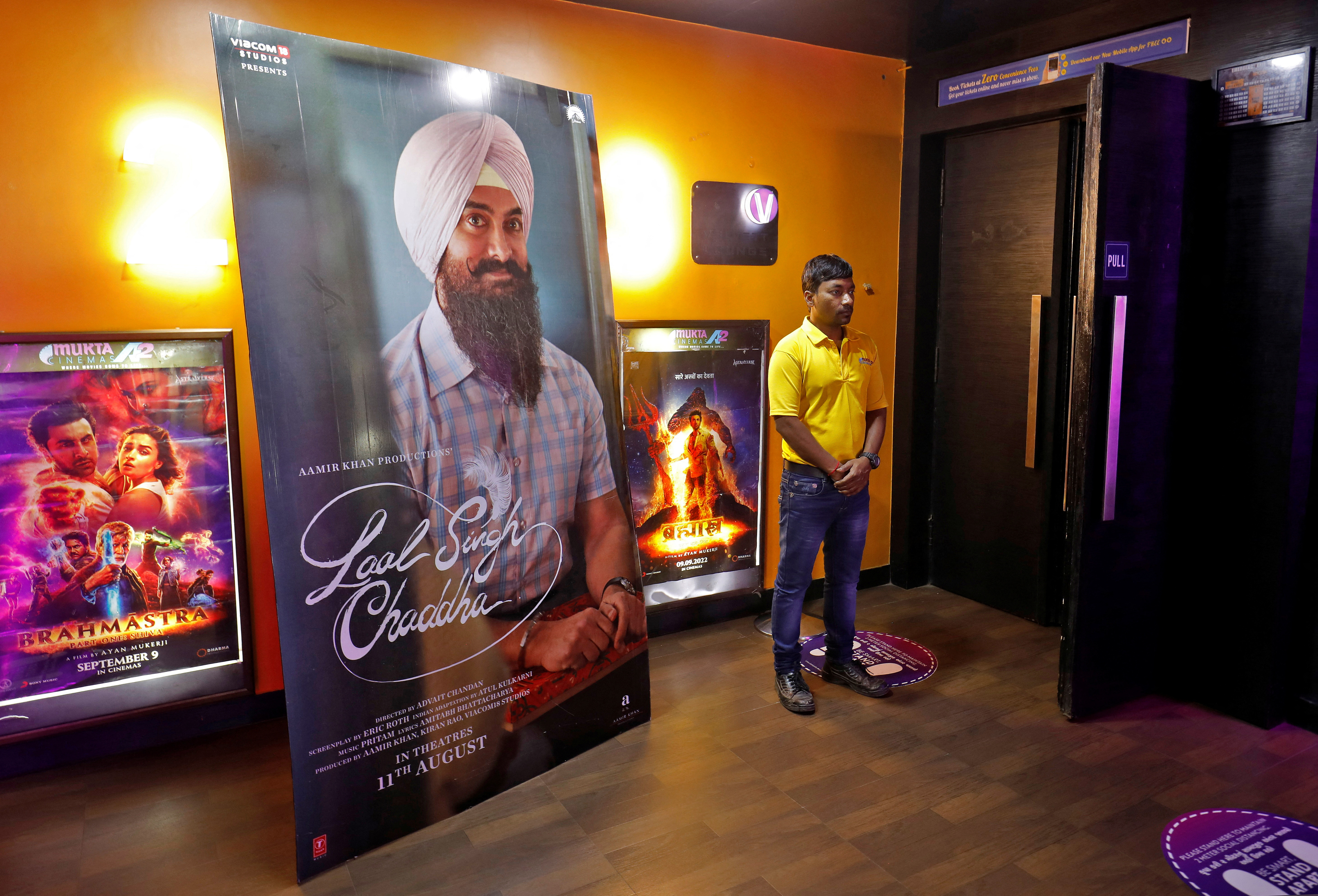 A ticket checker waits for film-goers at the gate of a cinema hall showcasing Aamir Khan-starrer "Laal Singh Chaddha", an official remake of the 1994 film "Forrest Gump" in Ahmedabad, India, August 26, 2022.