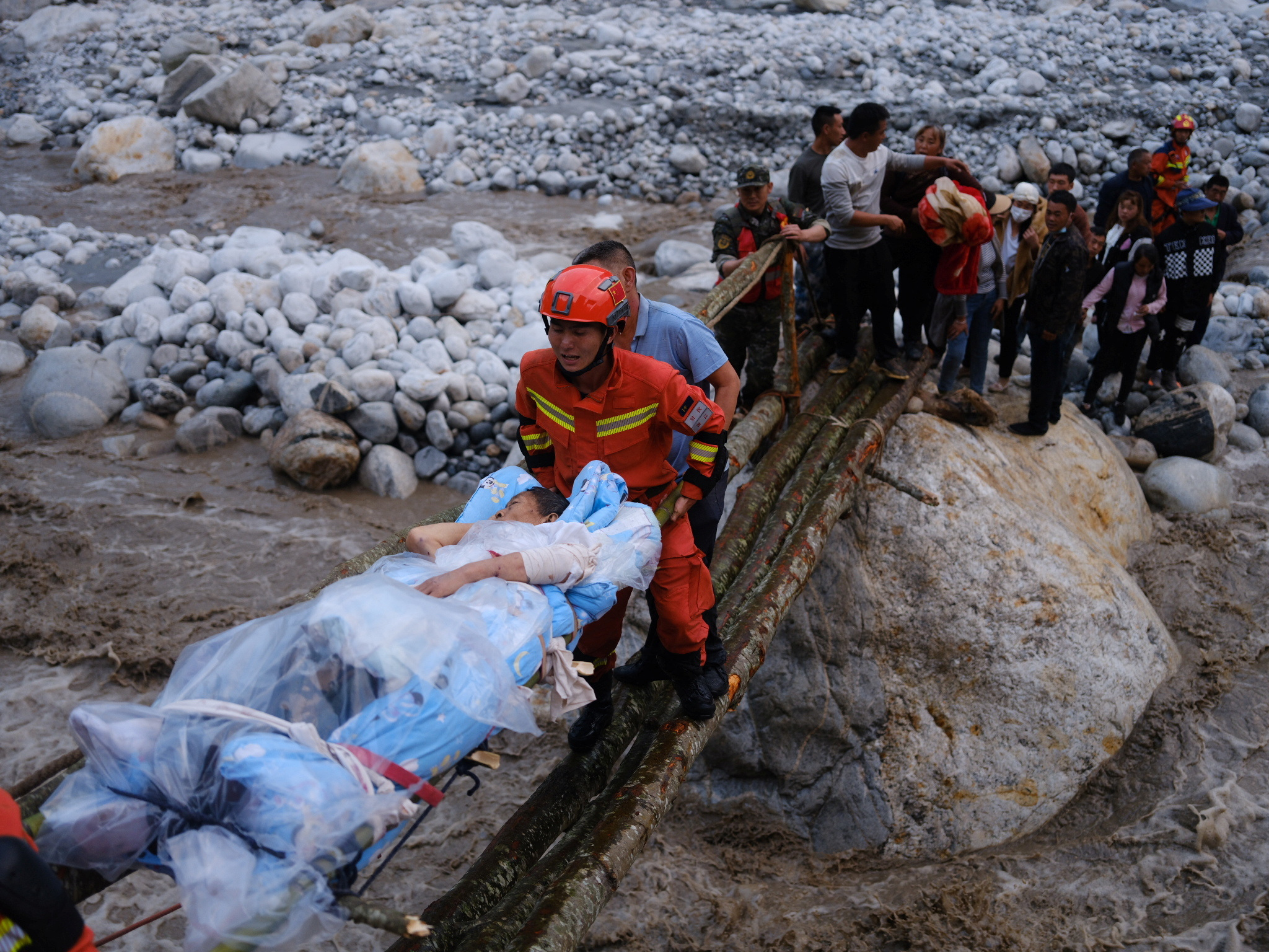 Rescue workers carry an injured victim on a stretcher following a 6.8-magnitude earthquake in Qinggangping village, Luding county, Sichuan province, China.