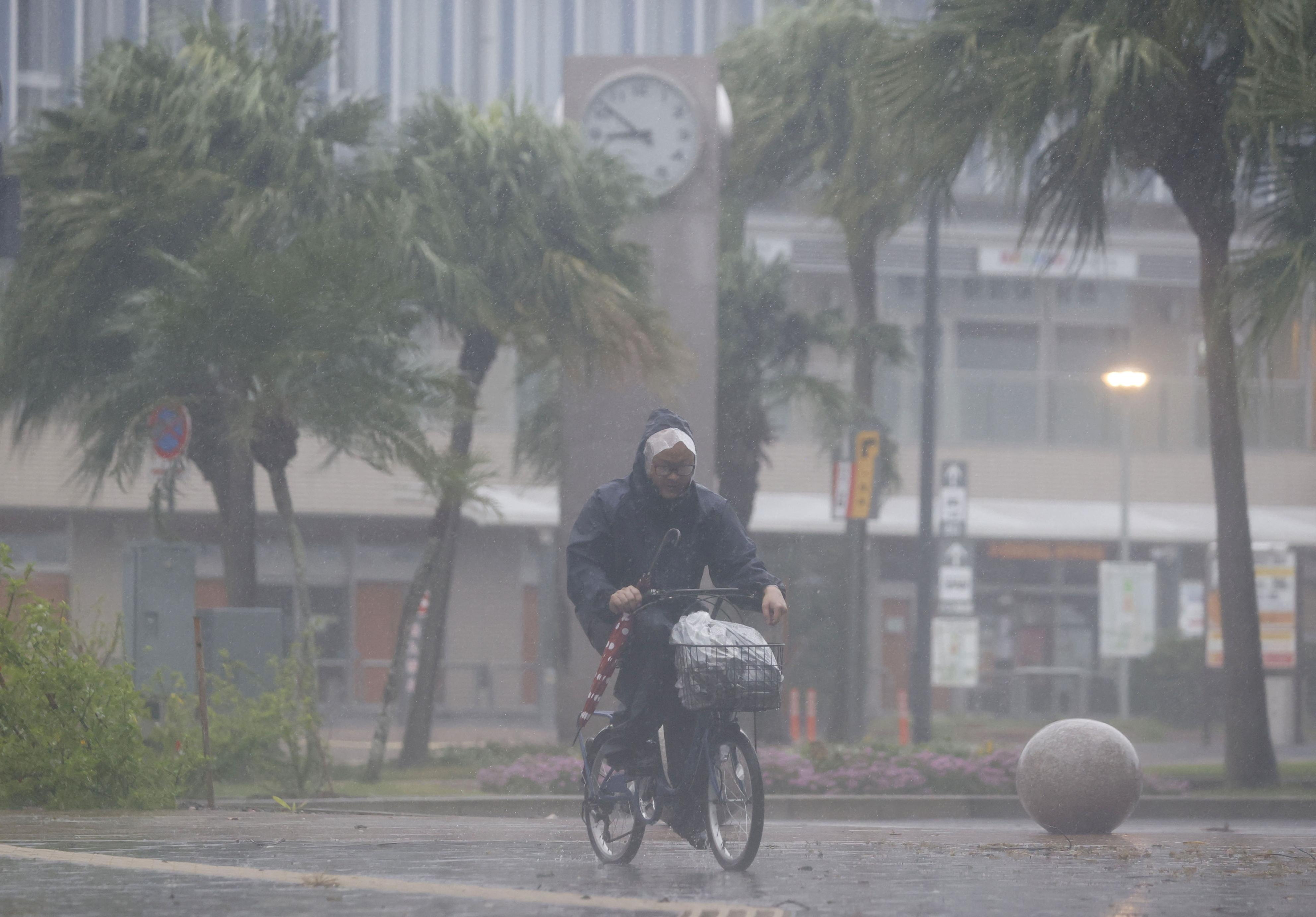 A man on a bicycle rides past in the heavy rain and wind caused by Typhoon Nanmadol in Miyazaki on Japan's southernmost main island of Kyushu September 18, 2022
