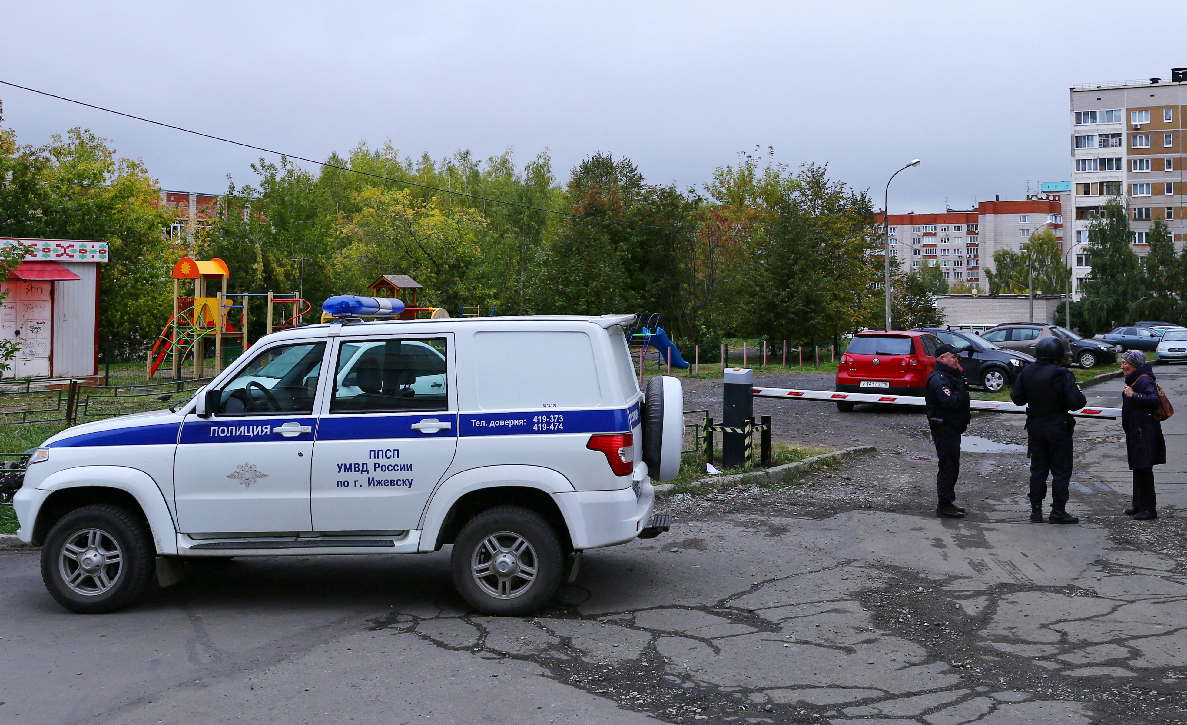 A woman talks to police officers securing area after a school shooting in Izhevsk, Russia