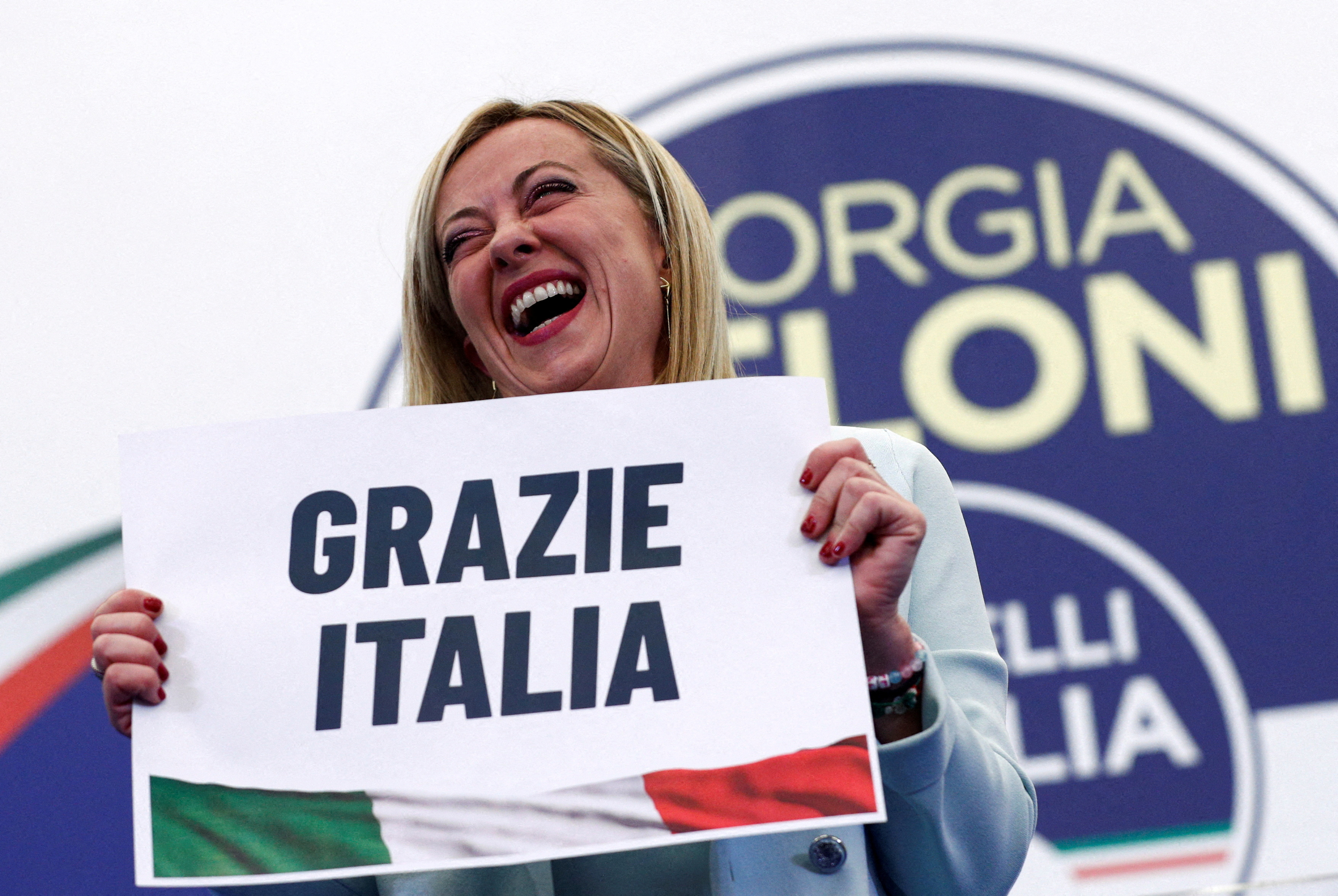 FILE PHOTO: Leader of Brothers of Italy Giorgia Meloni holds a sign at the party's election night headquarters, in Rome, Italy September 26, 2022.