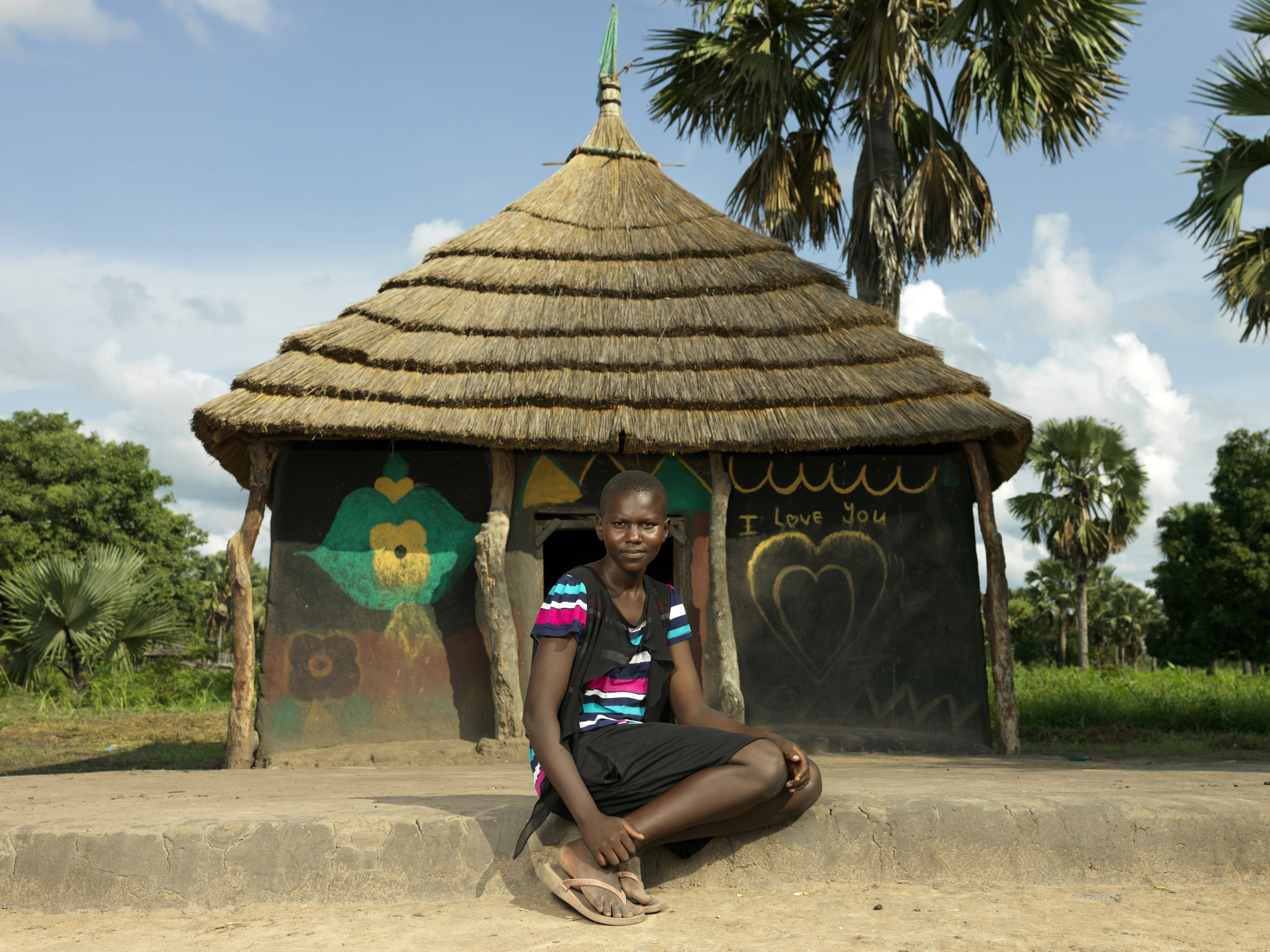 A photo of a girl sitting in front of a house.
