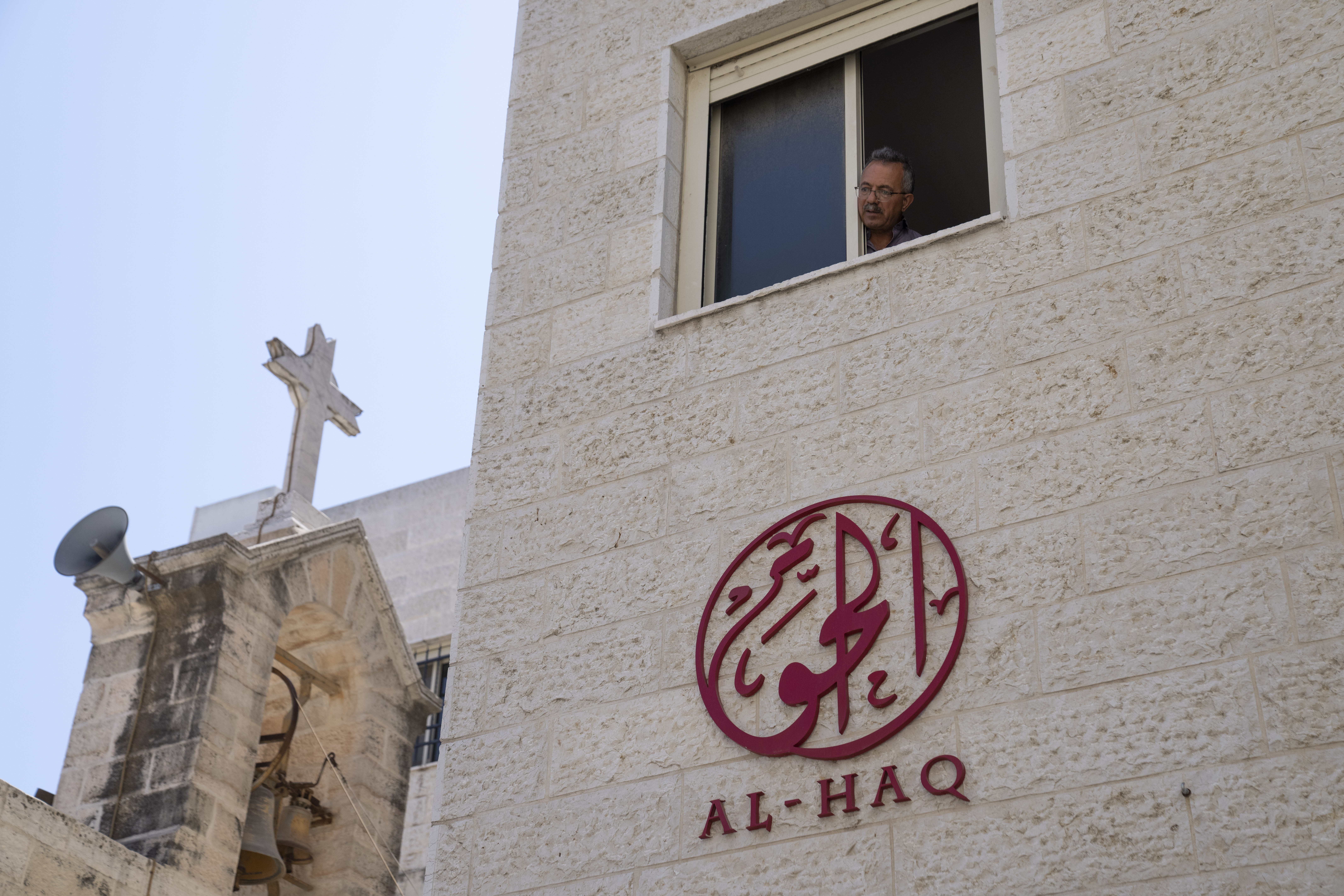 A man looks out of the window of the office of al-Haq, a Palestinian human rights organisation in the West Bank city of Ramallah on Aug. 18, 2022. The group is among seven that Israeli authorities are trying to close down, accusing them of ties to militants — even though international funders have found no evidence to back those claims.
