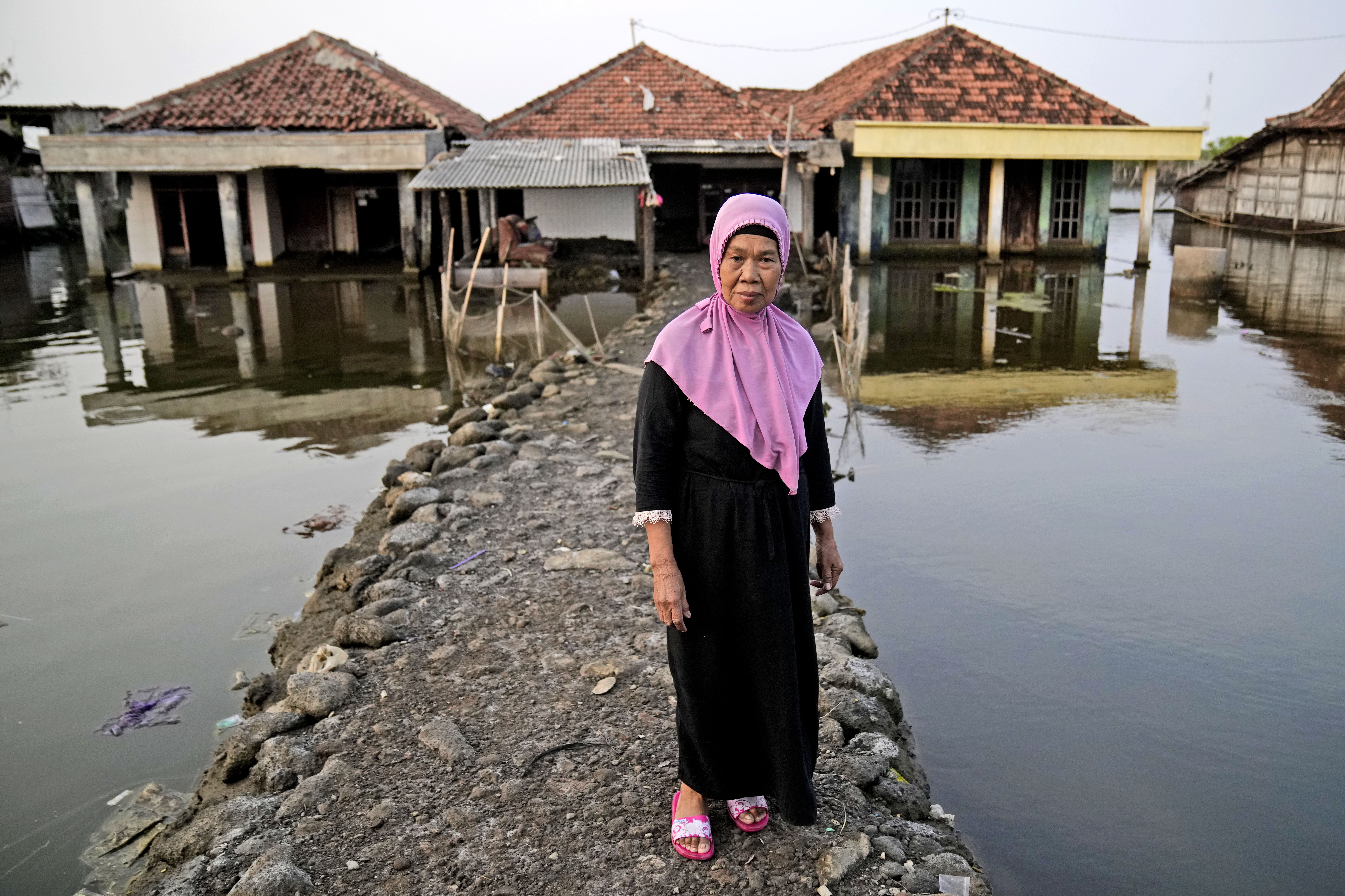 Kumaison stands on the pathway leading to her house