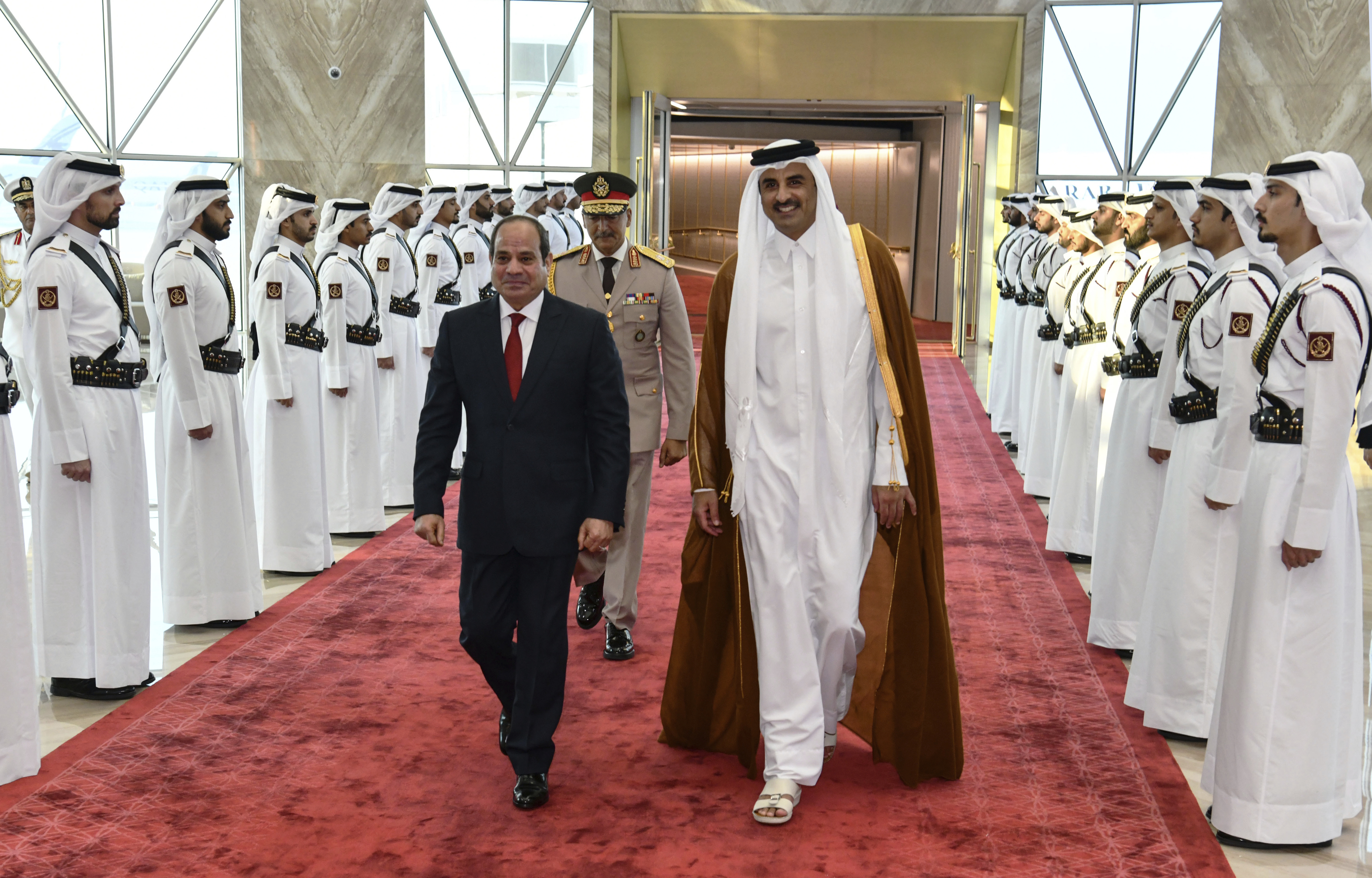 In this photo provided by Egypt's presidency media office, Qatari Emir Tamim bin Hamad Al Thani, right, accompanies Egyptian President Abdel-Fattah el-Sisi.