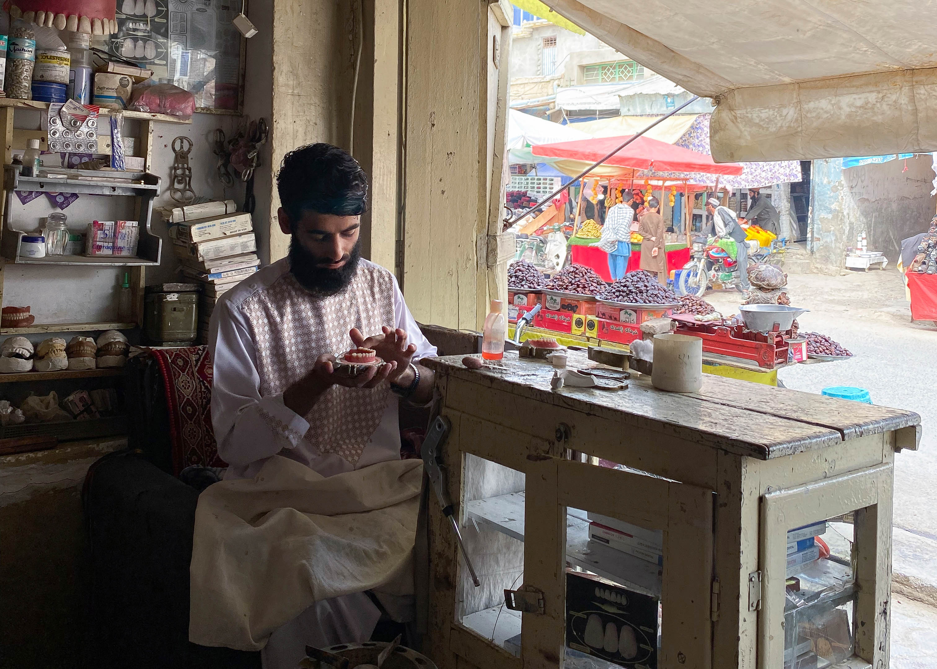 A photo of 23-year-old Ahmed Sayed holding a pair of dentures in his hand.