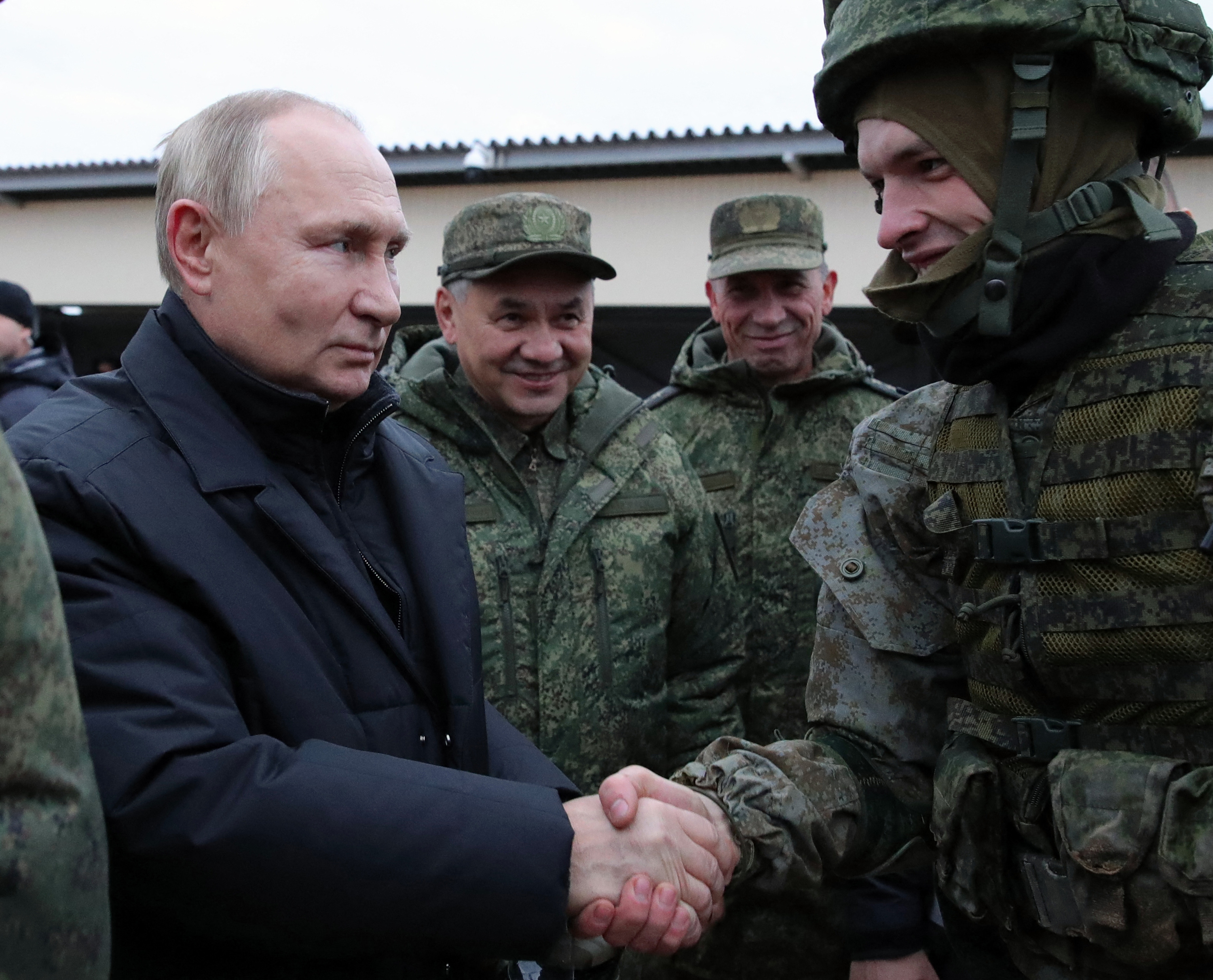 Russian President Vladimir Putin (L) and Defence Minister Sergei Shoigu (C) meet soldiers during a visit at a military training centre of the Western Military District for mobilised reservists, outside the town of Ryazan on October 20, 2022. (Photo by Mikhail Klimentyev / Sputnik / AFP)