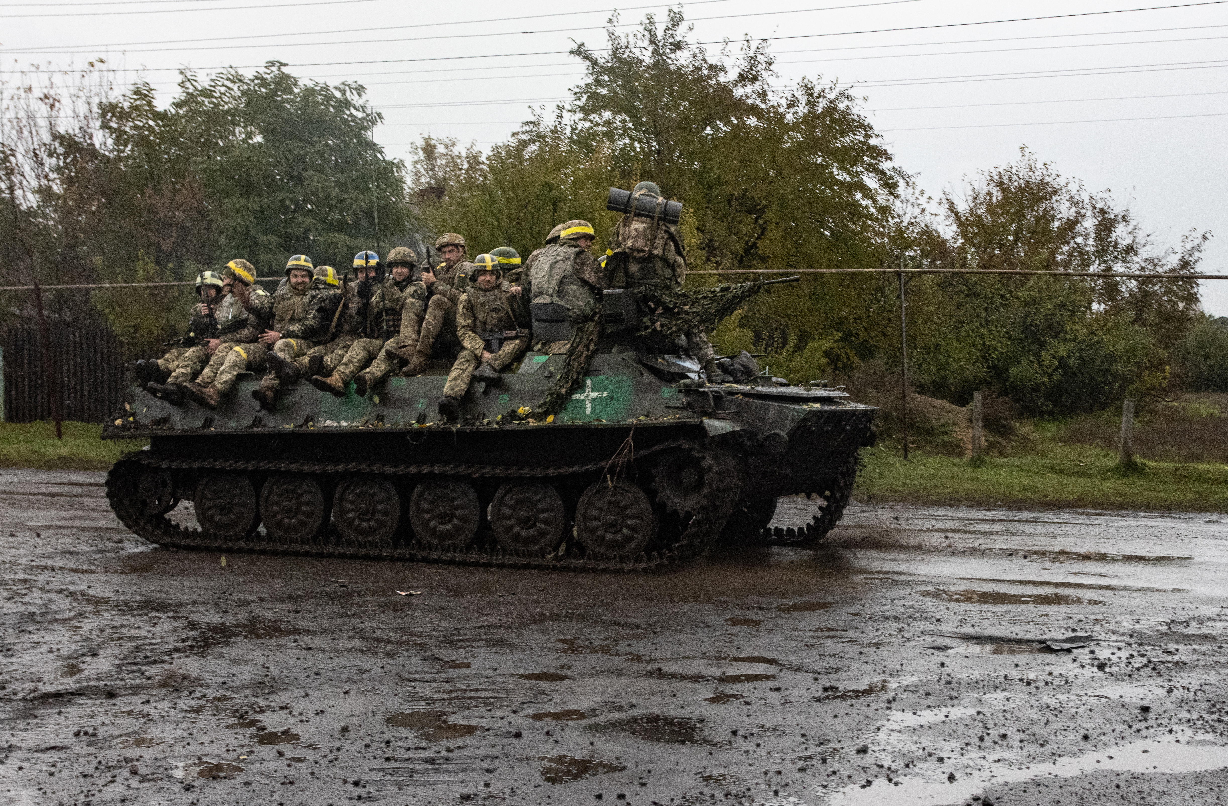 Ukrainian servicemen stand on an armoured personal carrier (APC) near Borivske, Kharkiv region