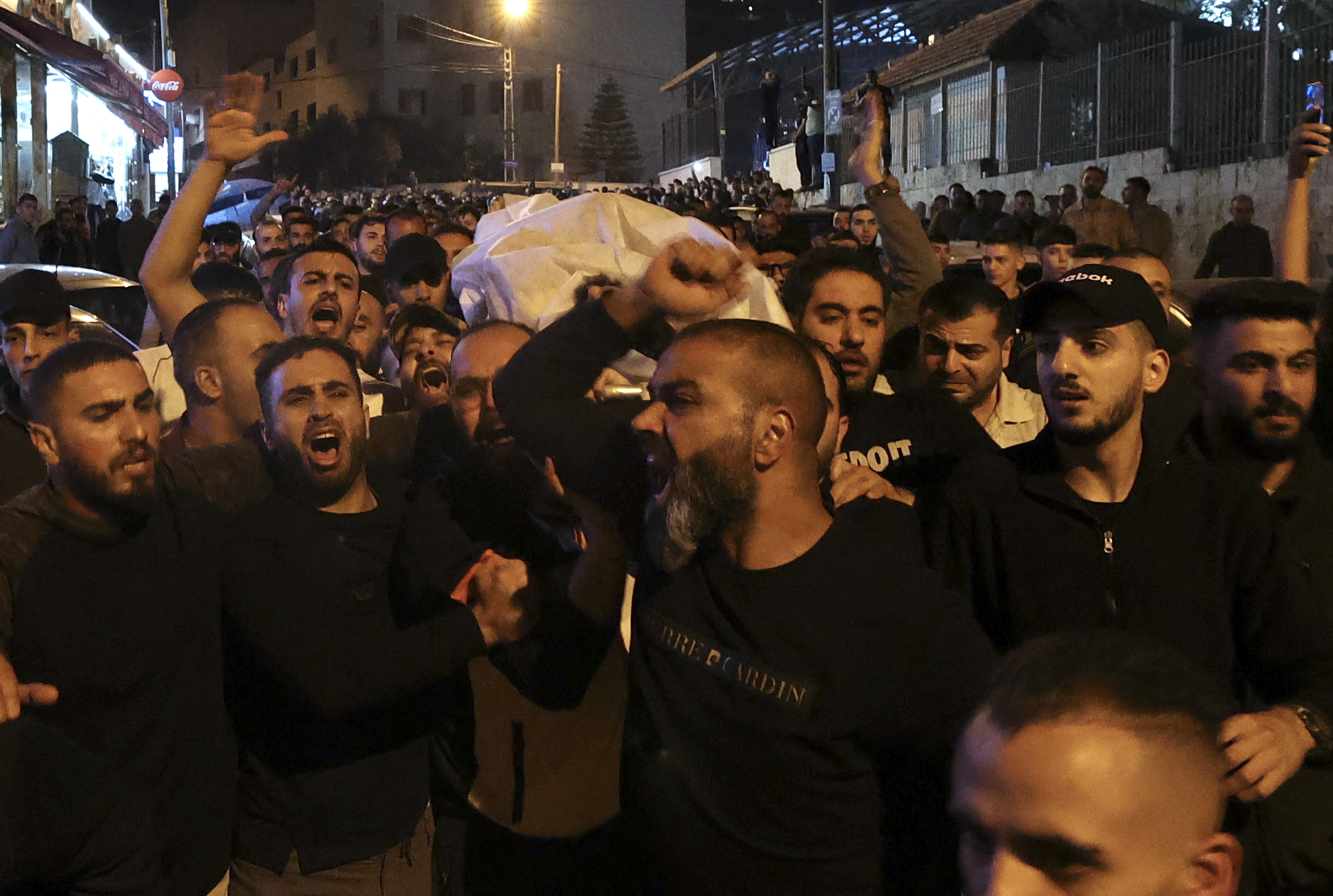 The body of a Palestinian man killed by Israeli forces is carried in Nablus in the occupied West Bank in the early hours of October 25, 2022 [Jaafar Ashtiyeh/ AFP]