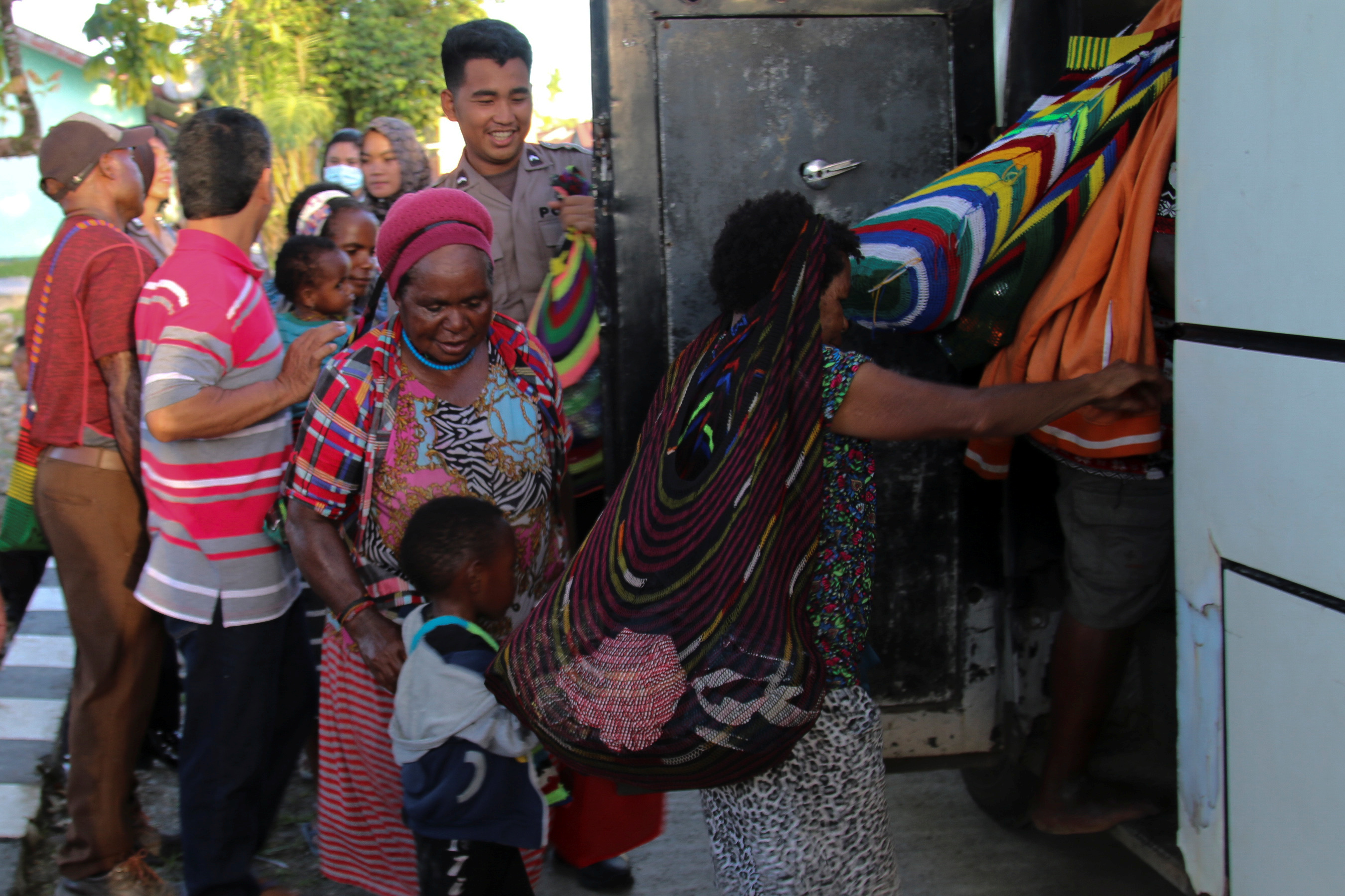 Papuan women and children get into the back of an evacuation bus after clashes between the Indonesian military and armed groups