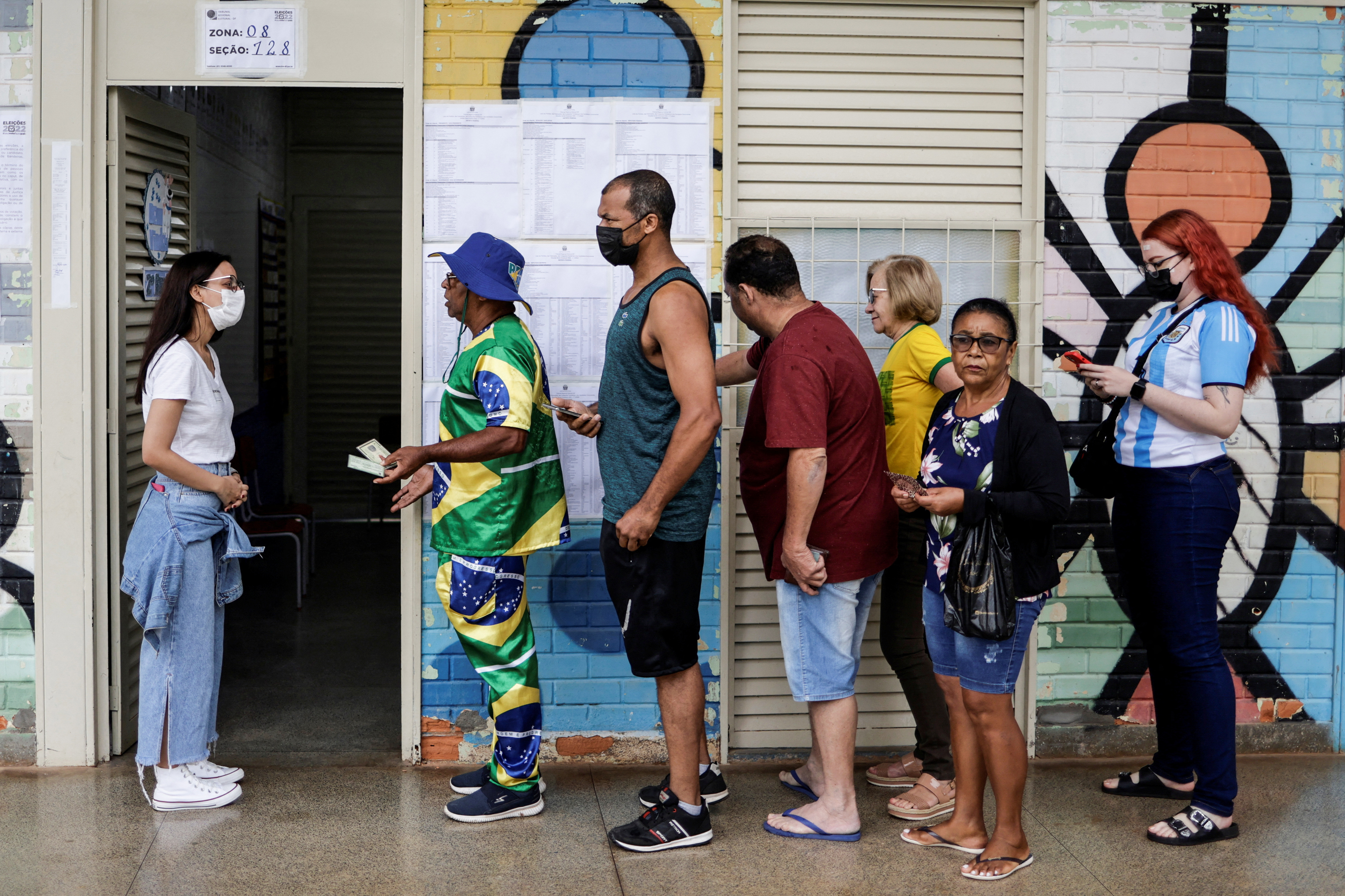 A supporter of Brazil's president and candidate for re-election Jair Bolsonaro, Mauro Pinto waits in line to cast his vote at a polling station, in Brasilia, Brazil.