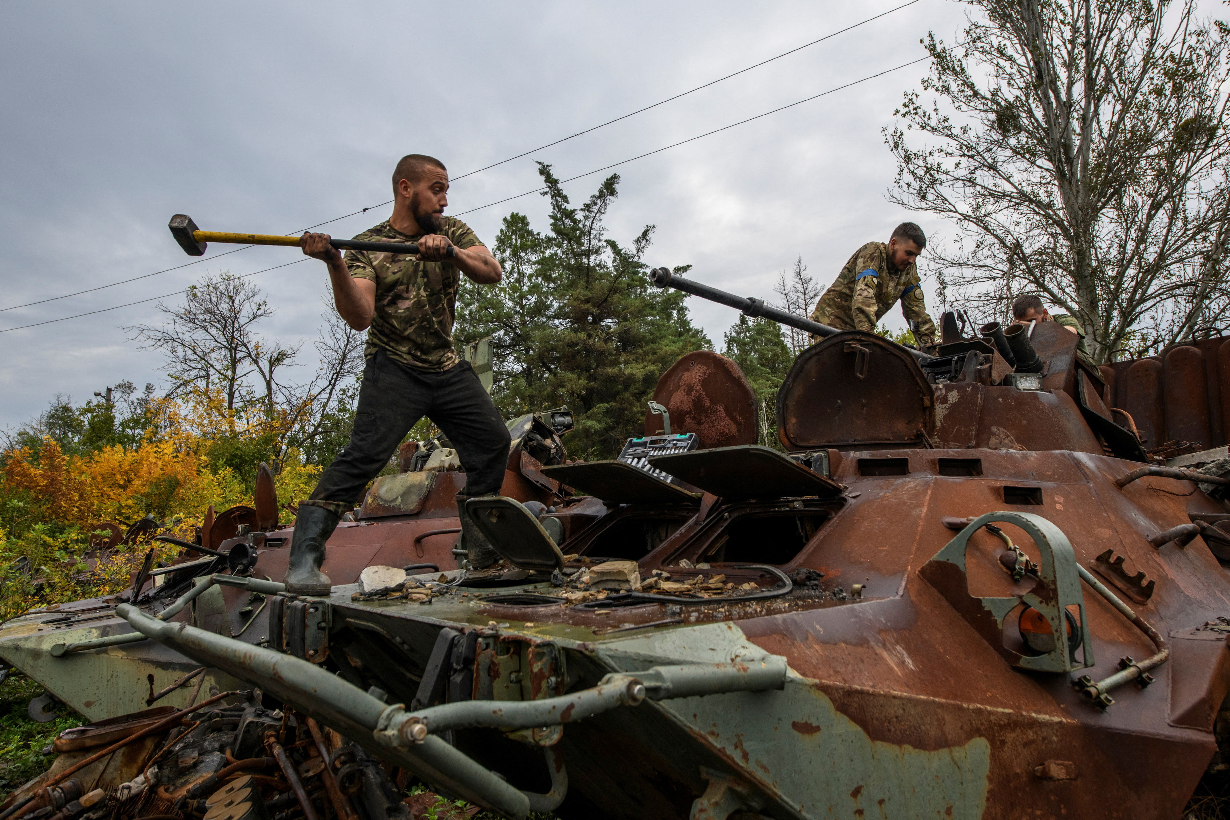 Ukrainian servicemen members dismount a cannon from a captured Russian armoured personnel carrier.