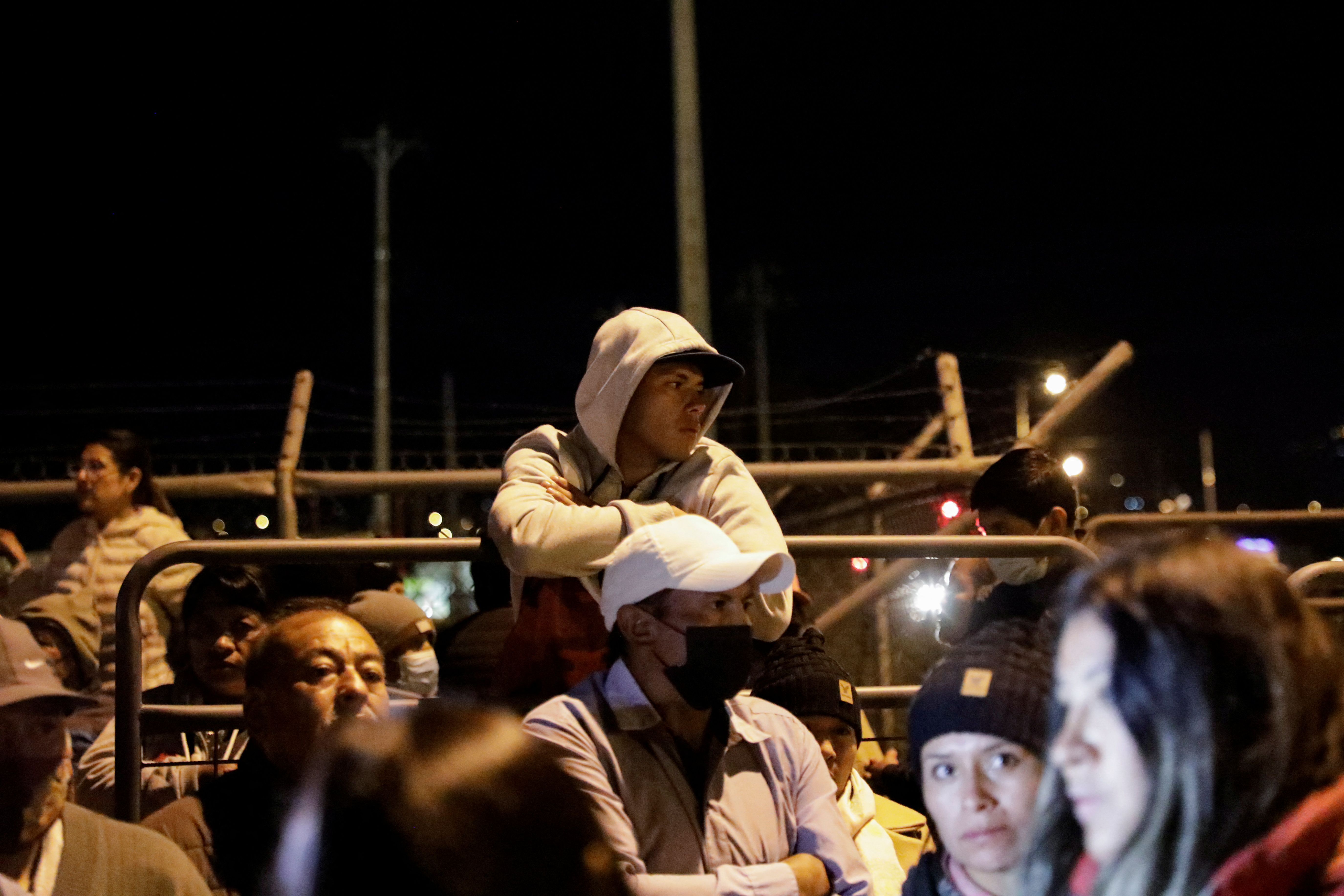 Family members wrapped up against the cold with hoodies and scarves wait outside the prison for news of inmates inside.