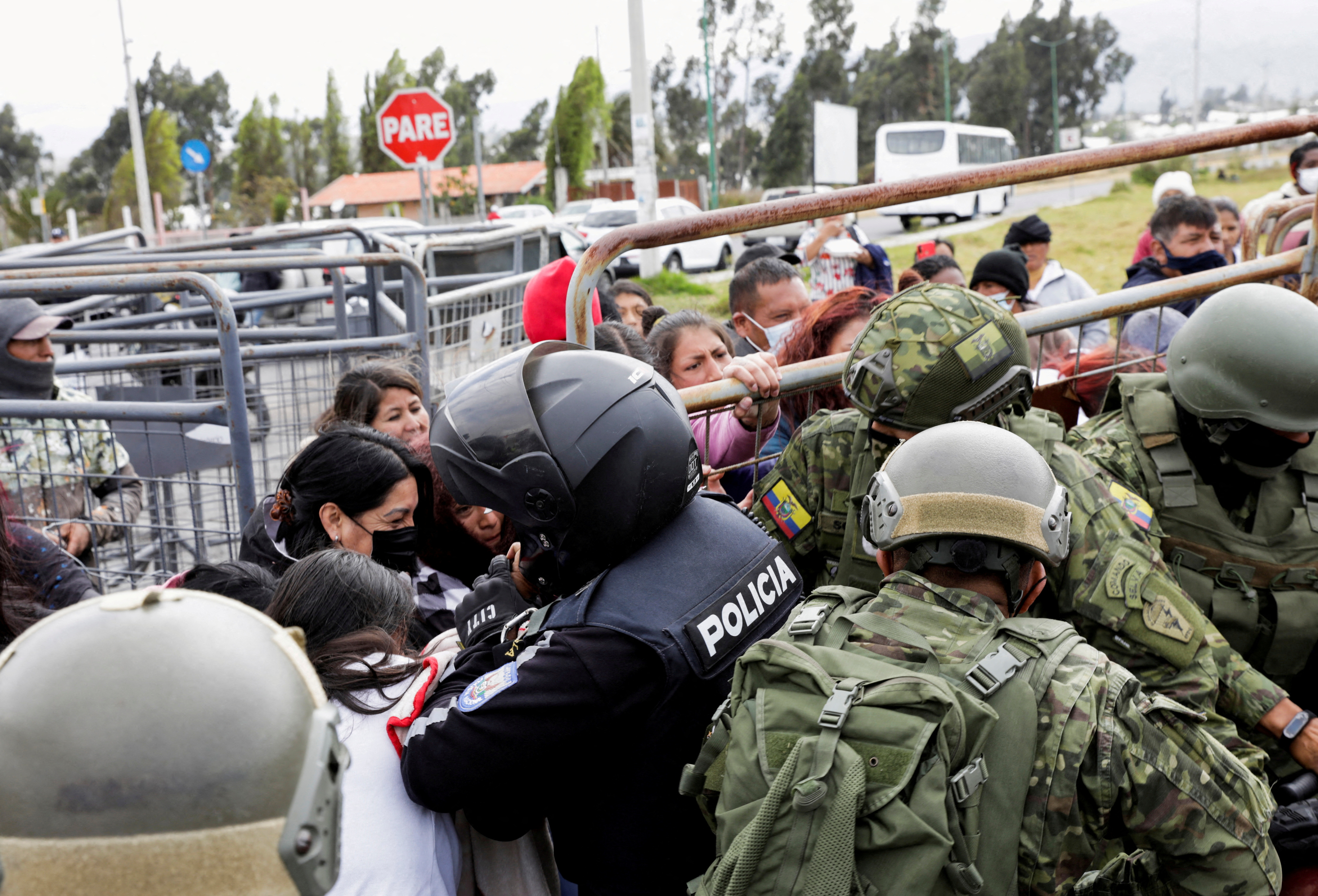 Relatives push fences outside an Ecuadorian prison