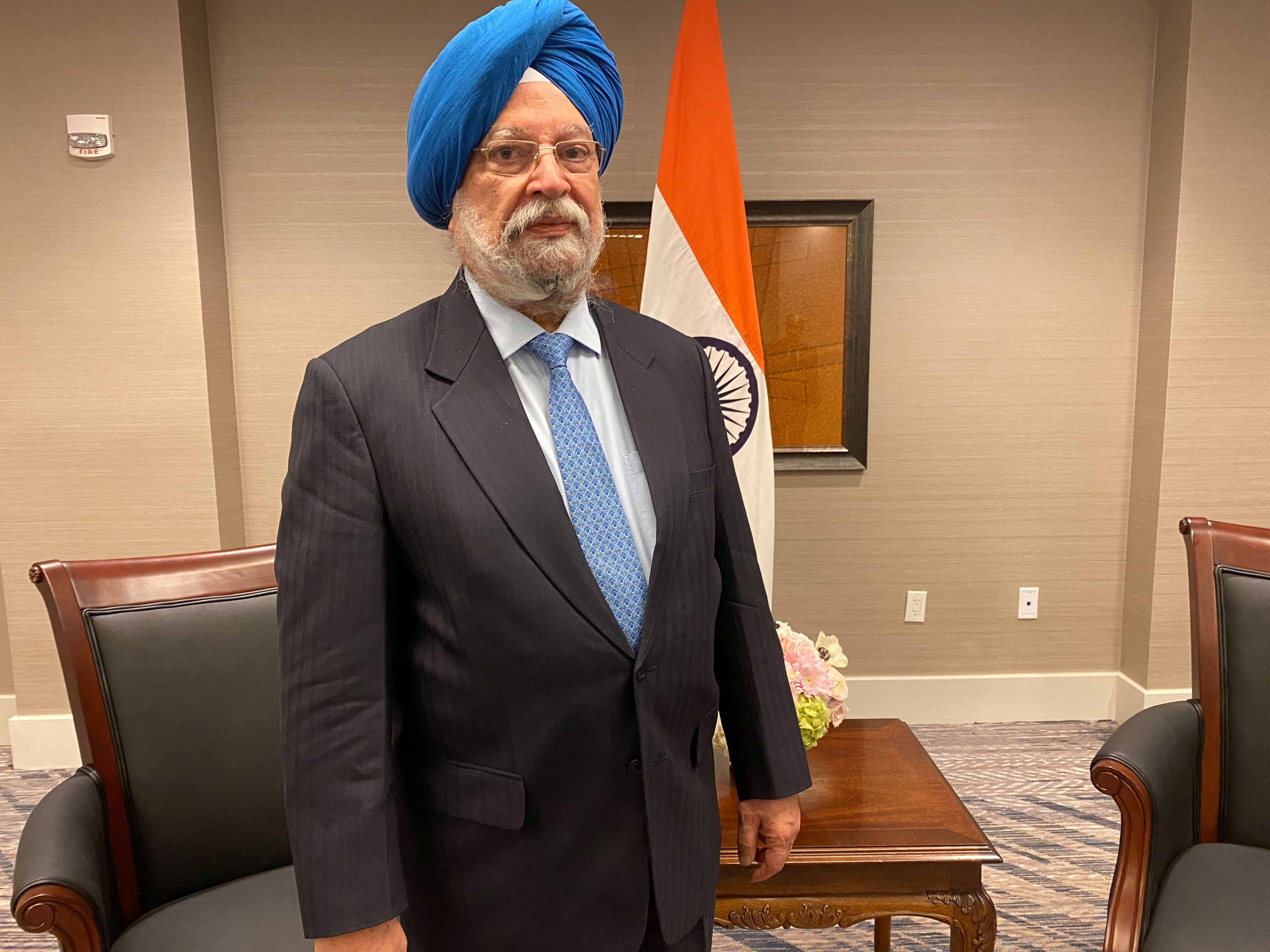Hardeep Singh Puri in office, with flag, table and desk behind him