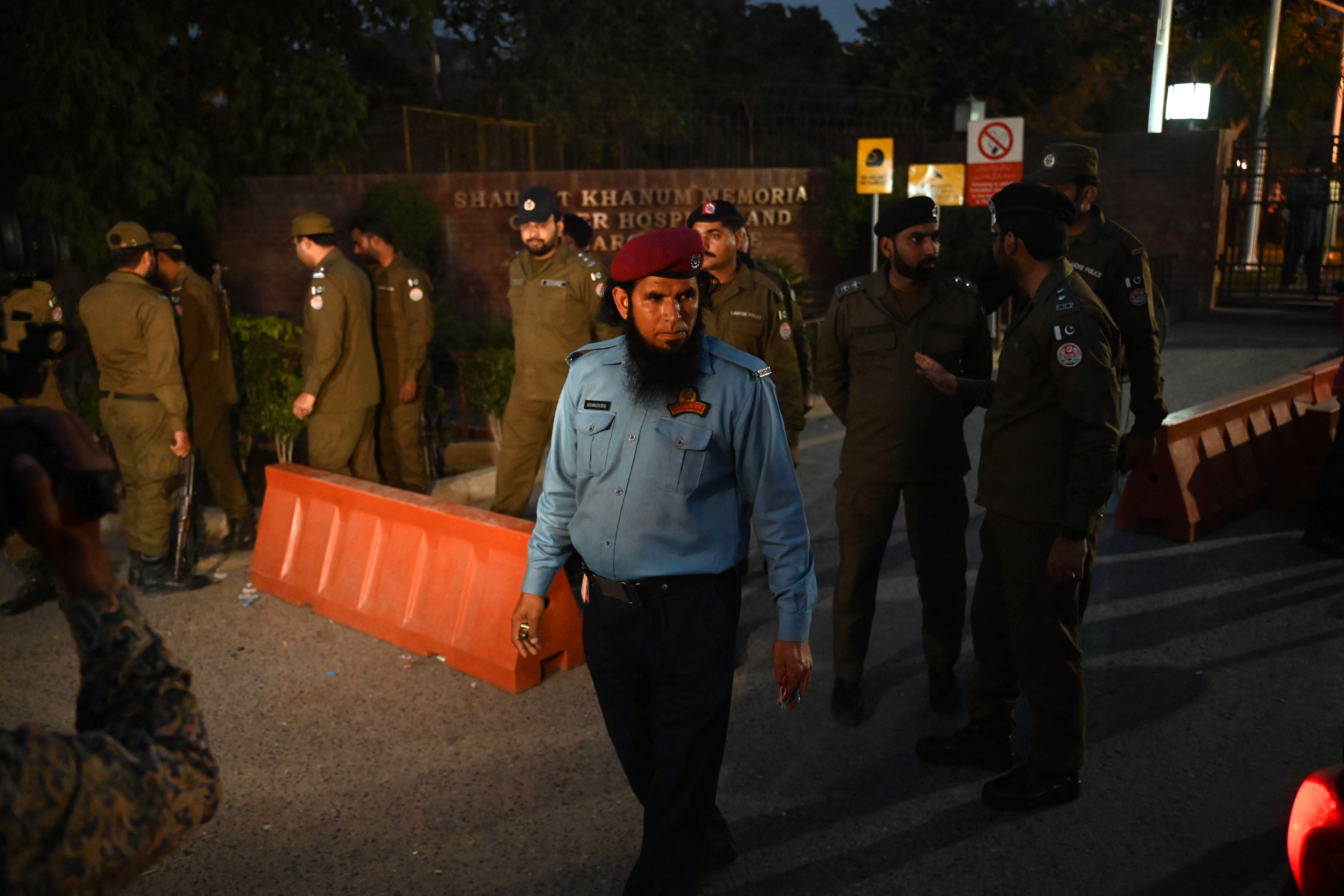 Policemen stand guard at the gate of a hospita