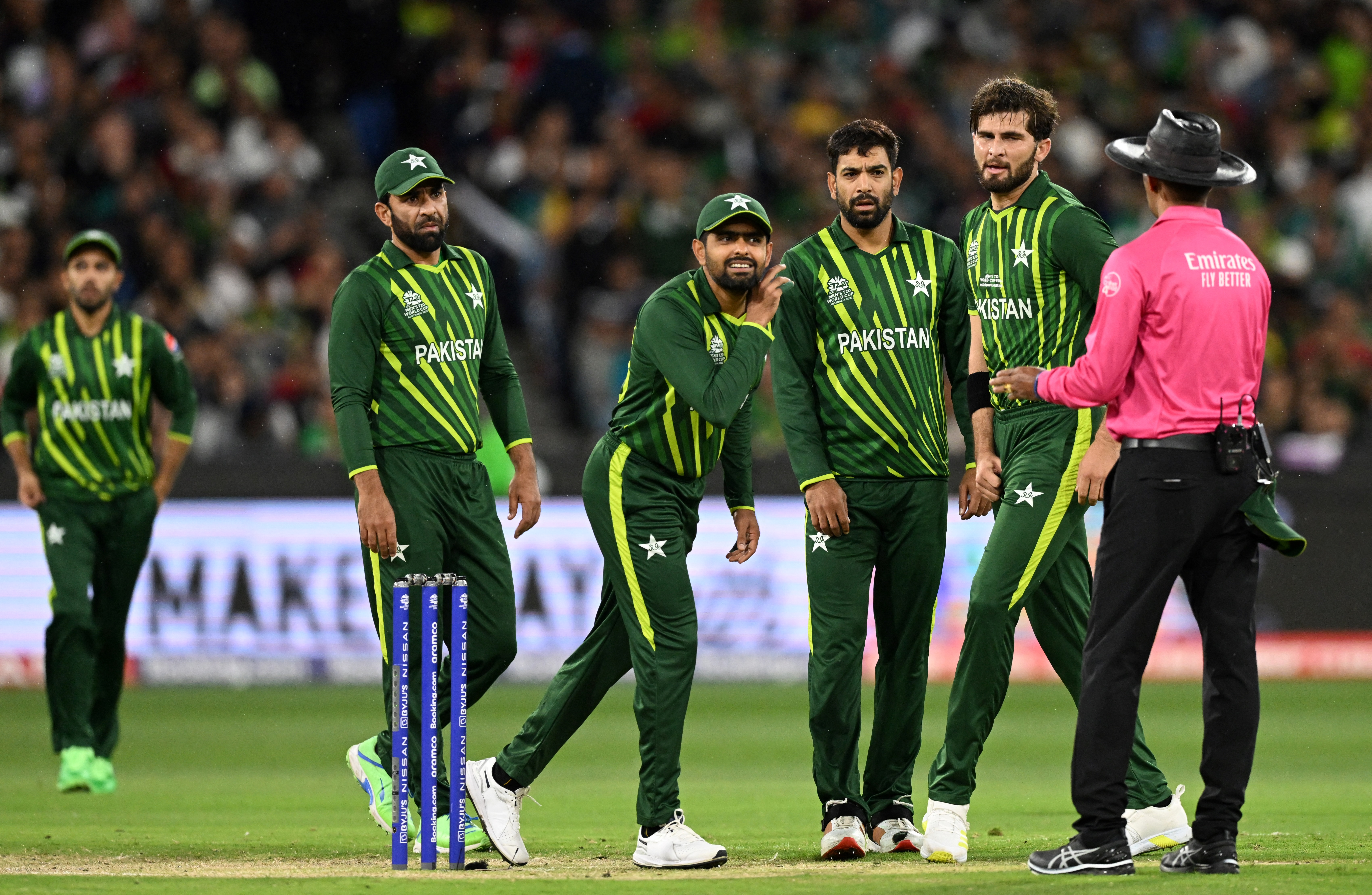 Pakistan's Captain Babar Azam (C) listens to Sri Lanka's umpire Kumar Dharmasena (R) during the ICC men's Twenty20 World Cup 2022 final