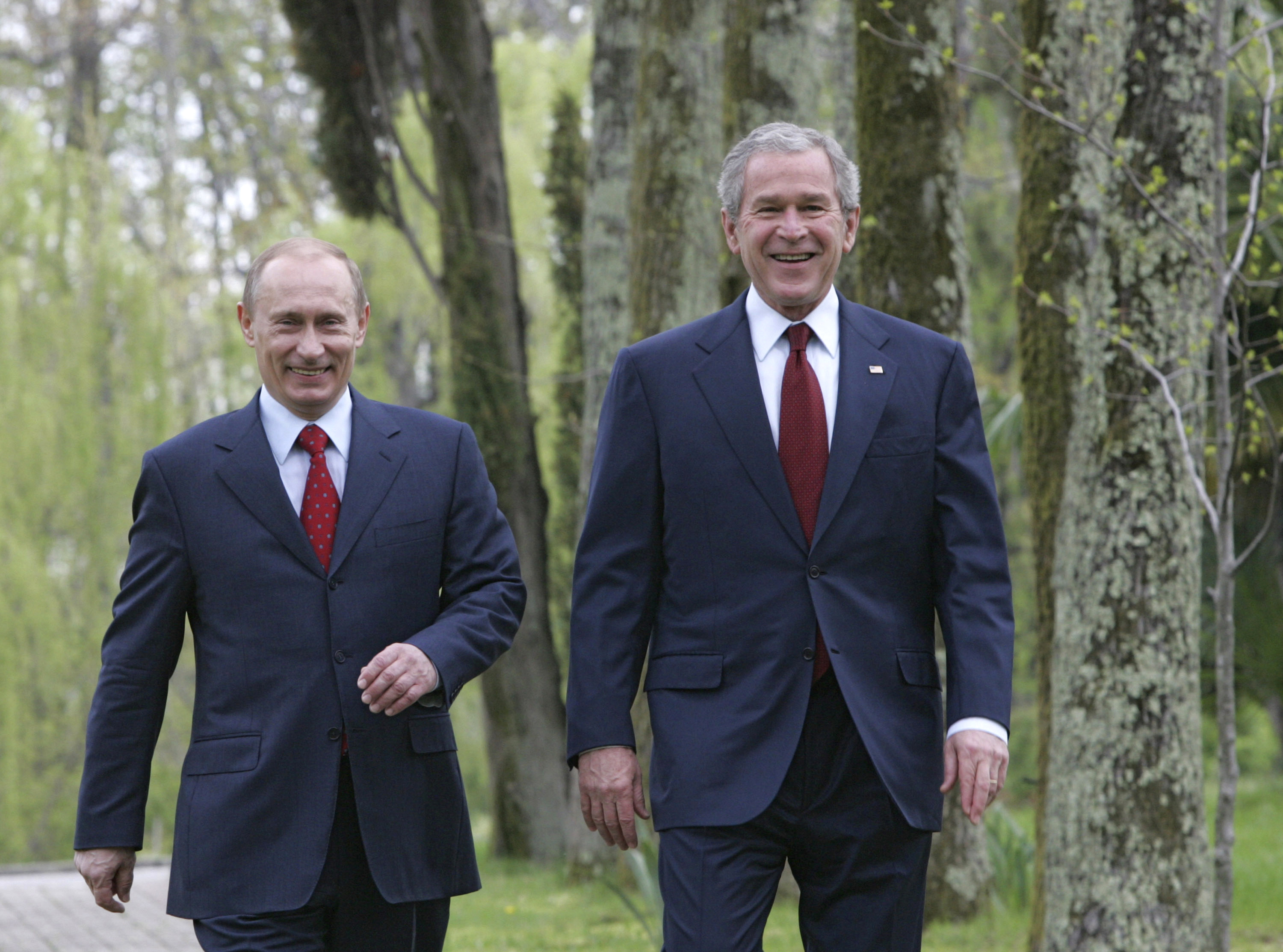 Russian President Vladimir Putin and then-US President George Bush walk at Putin's Black Sea summer retreat, Bocharov Ruchey, in Sochi on April 6, 2008