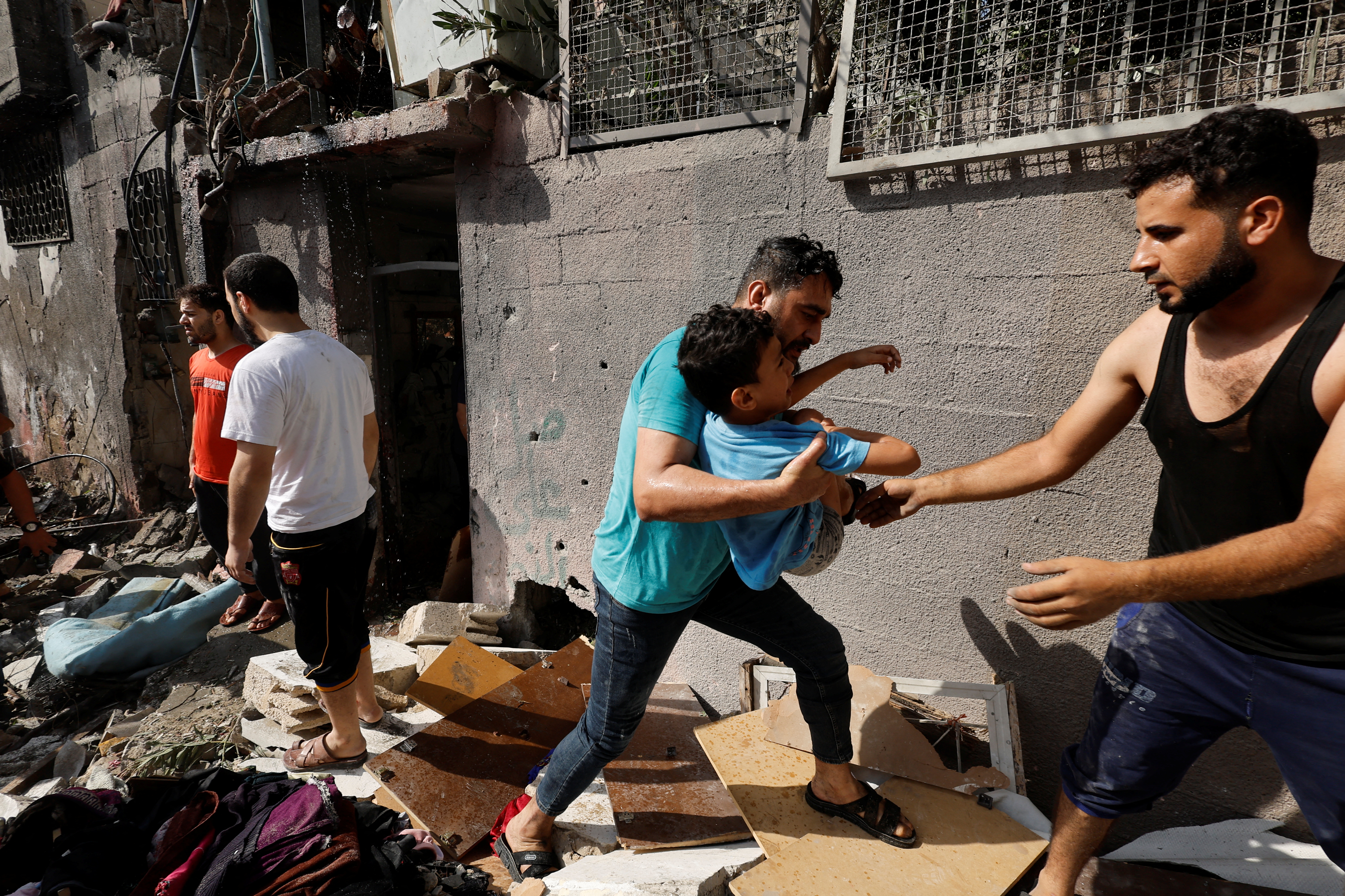 Palestinians evacuate a boy following an Israeli air strike on a house, amid Israel-Gaza fighting, in the northern Gaza Strip August 7, 2022. REUTERS/Mohammed Salem