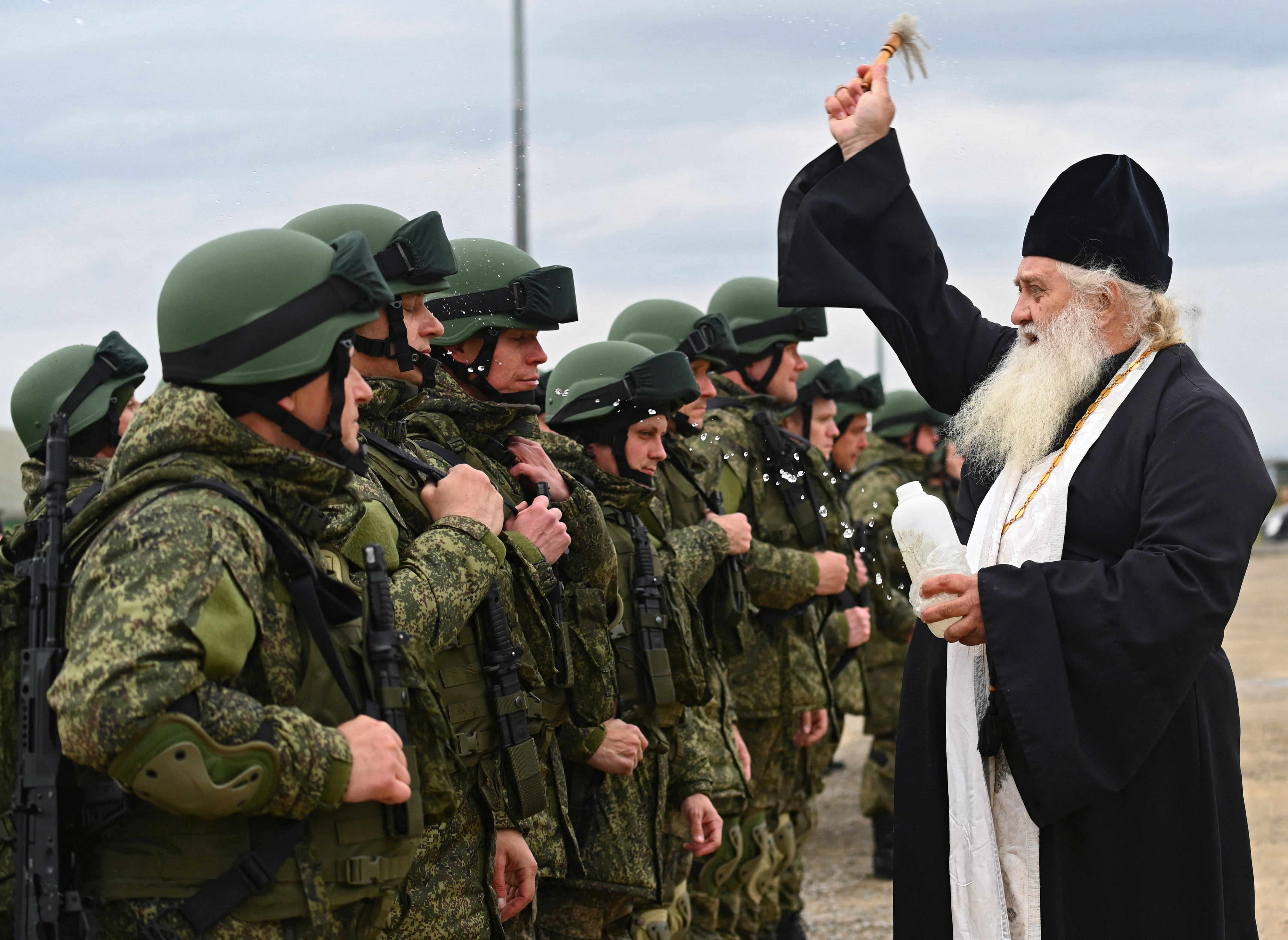 A priest sprinkles holy water on Russian reservists recruited during the partial mobilisation of troops before their departure to the zone of Russia-Ukraine conflict, in the Rostov region, Russia October 31, 2022. REUTERS/Sergey Pivovarov