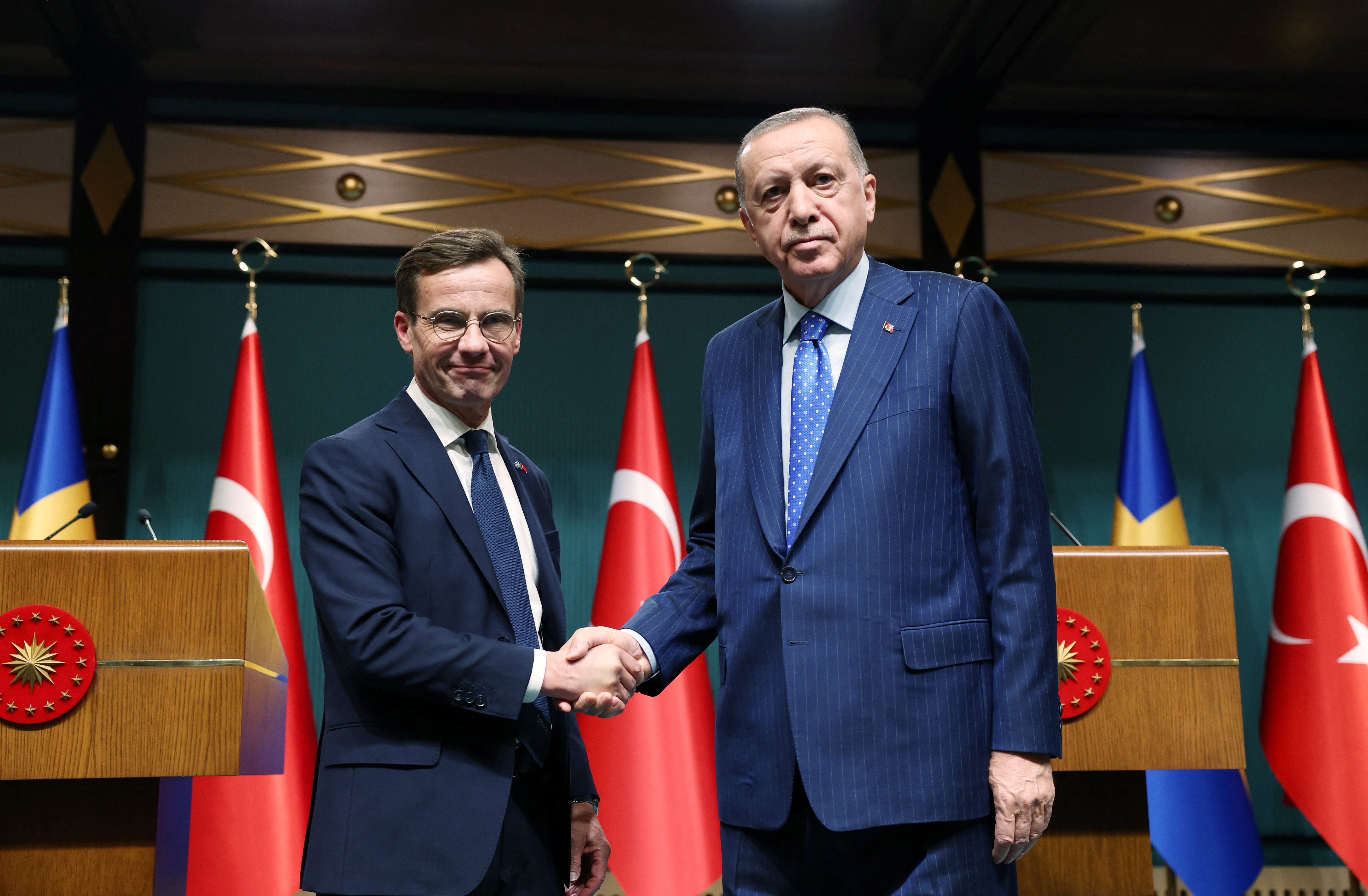 Turkish President Recep Tayyip Erdogan and Swedish Prime Minister Ulf Kristersson shake hands.