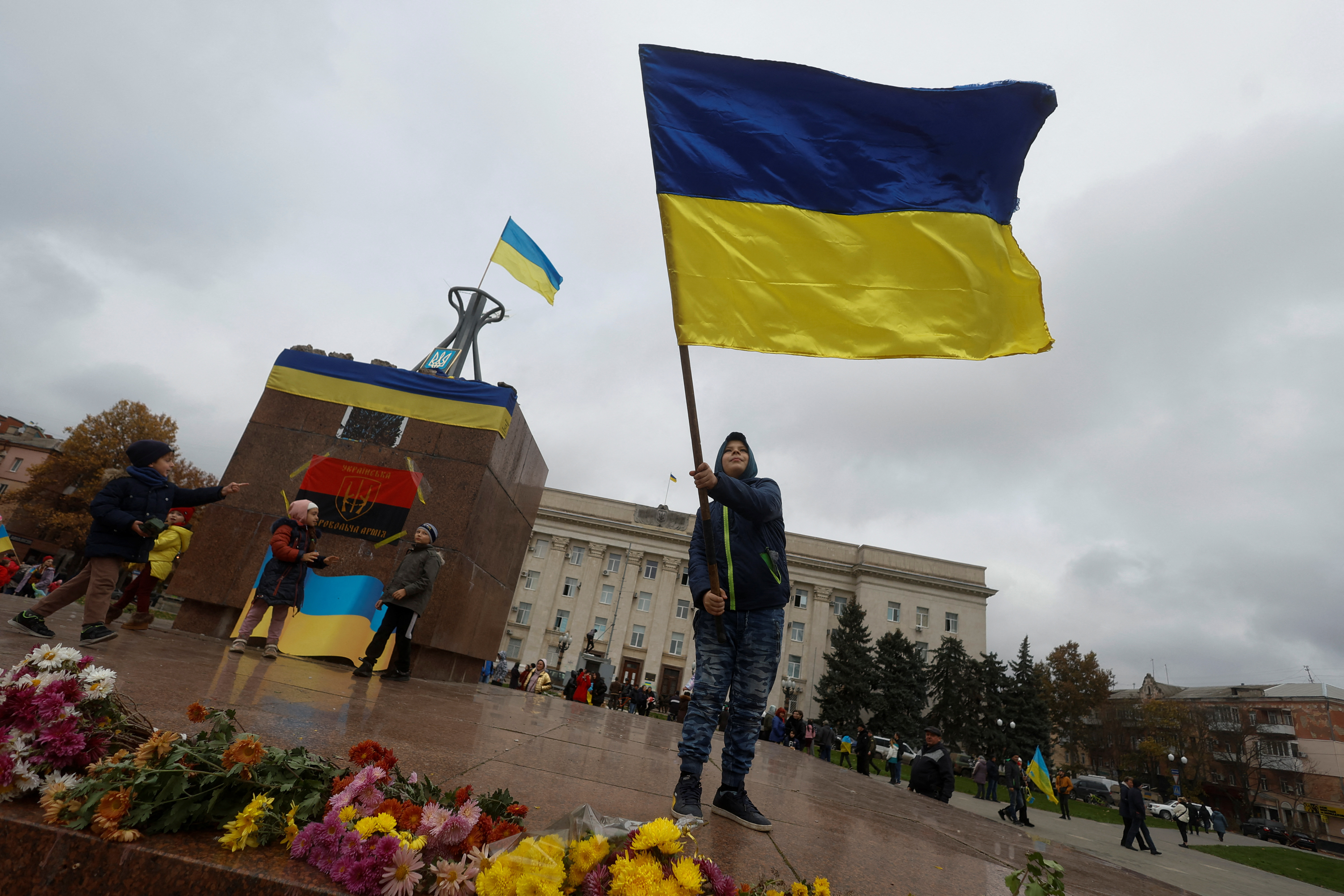 A boy waves a national flag as he celebrates after Russia's retreat from Kherson, in central Kherson, Ukraine November 13, 2022