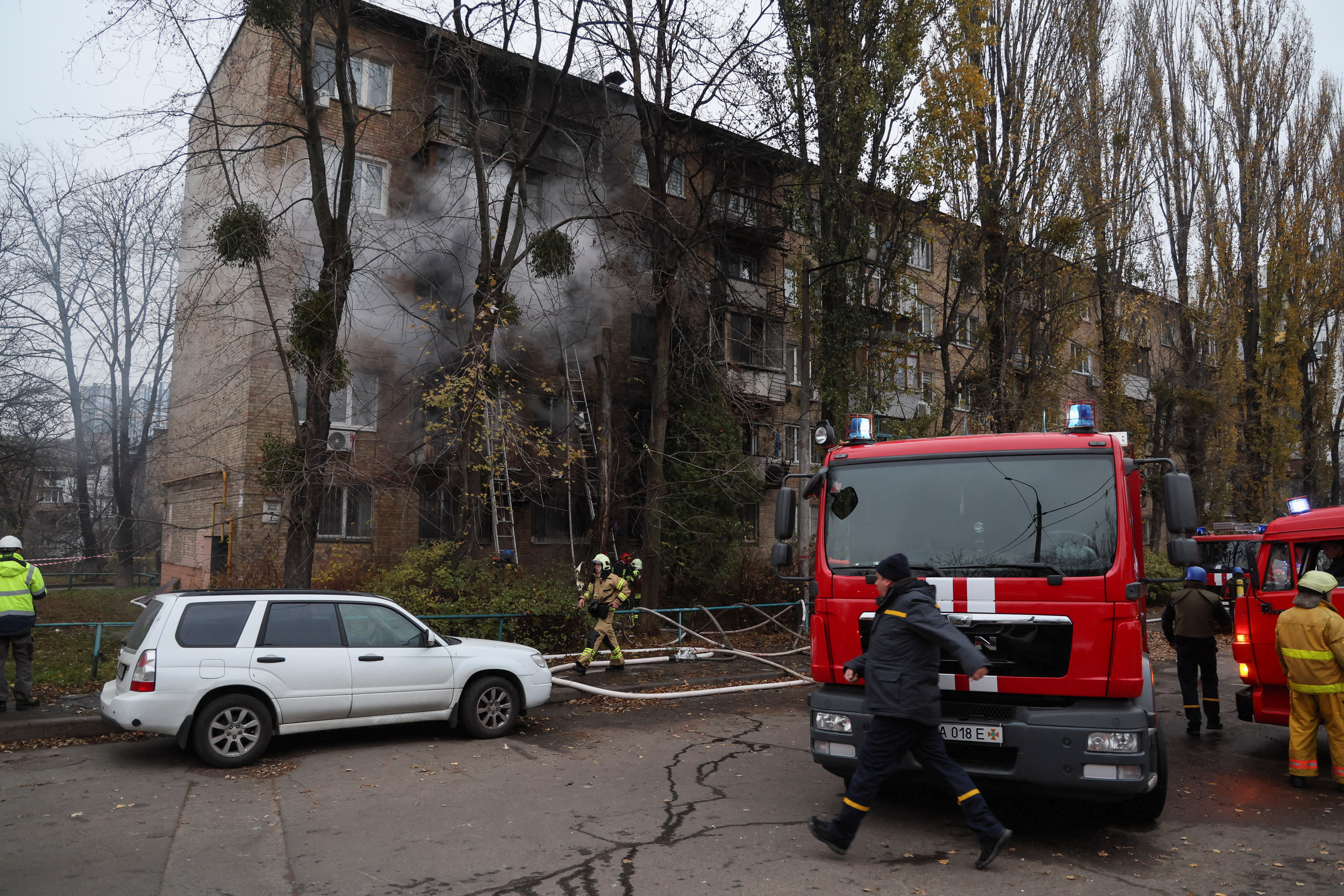 Firefighters work to put out a fire in a residential building hit by a Russian missile.