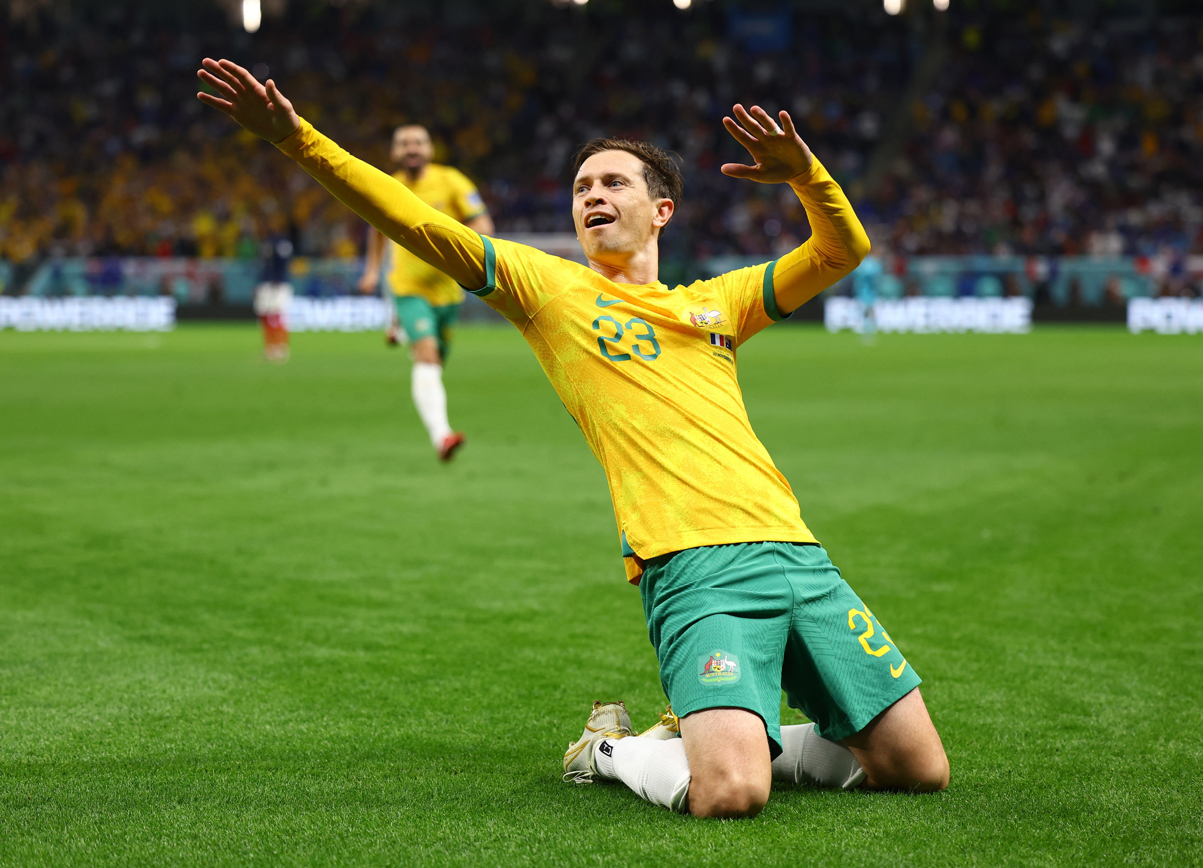 Goodwin on his knees, with both arms up, one pointing to the right