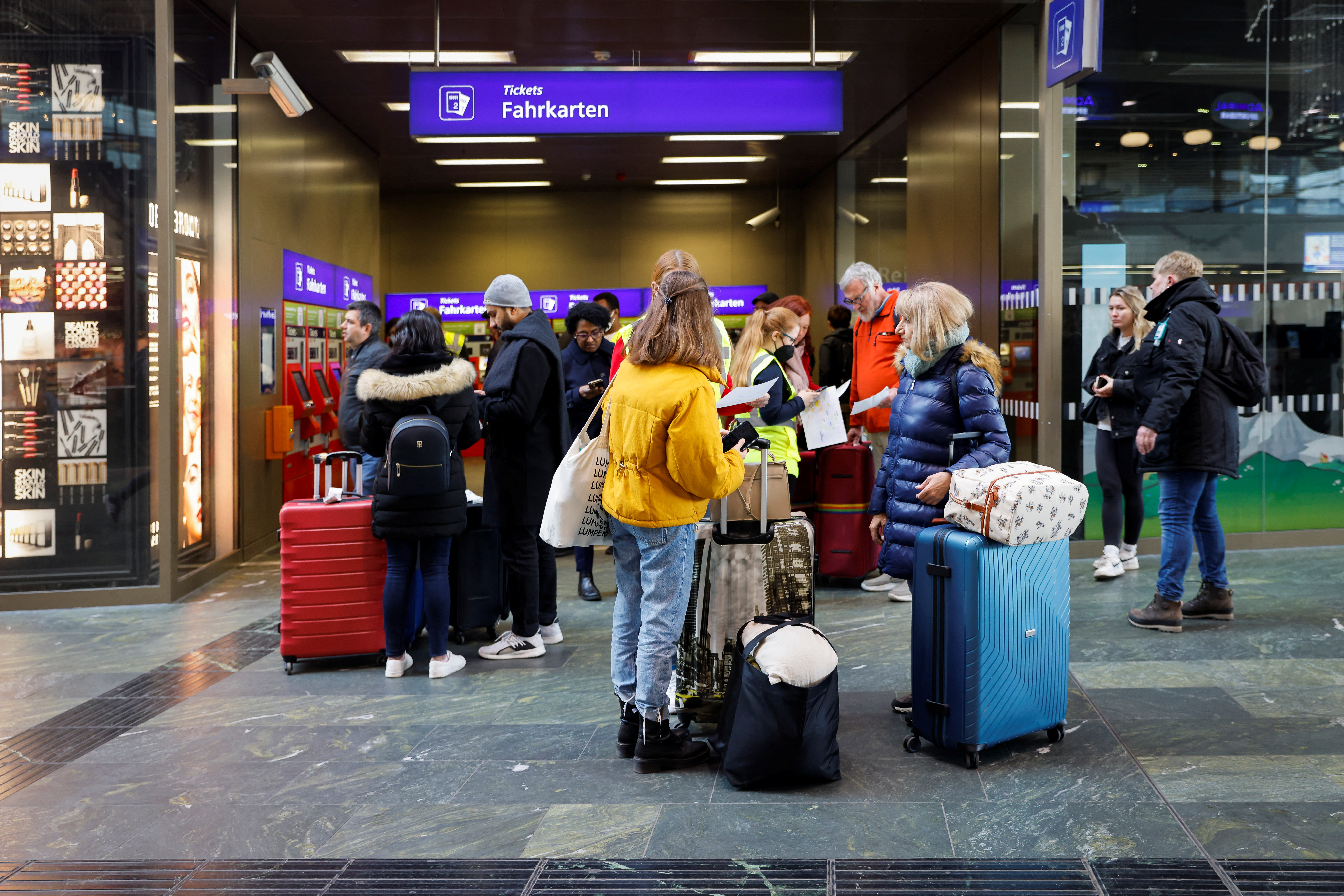 Travellers stand at the central station as Austria's rail workers stage a strike that shuts down all train traffic throughout the country after last minute pay negotiations fell through in Vienna