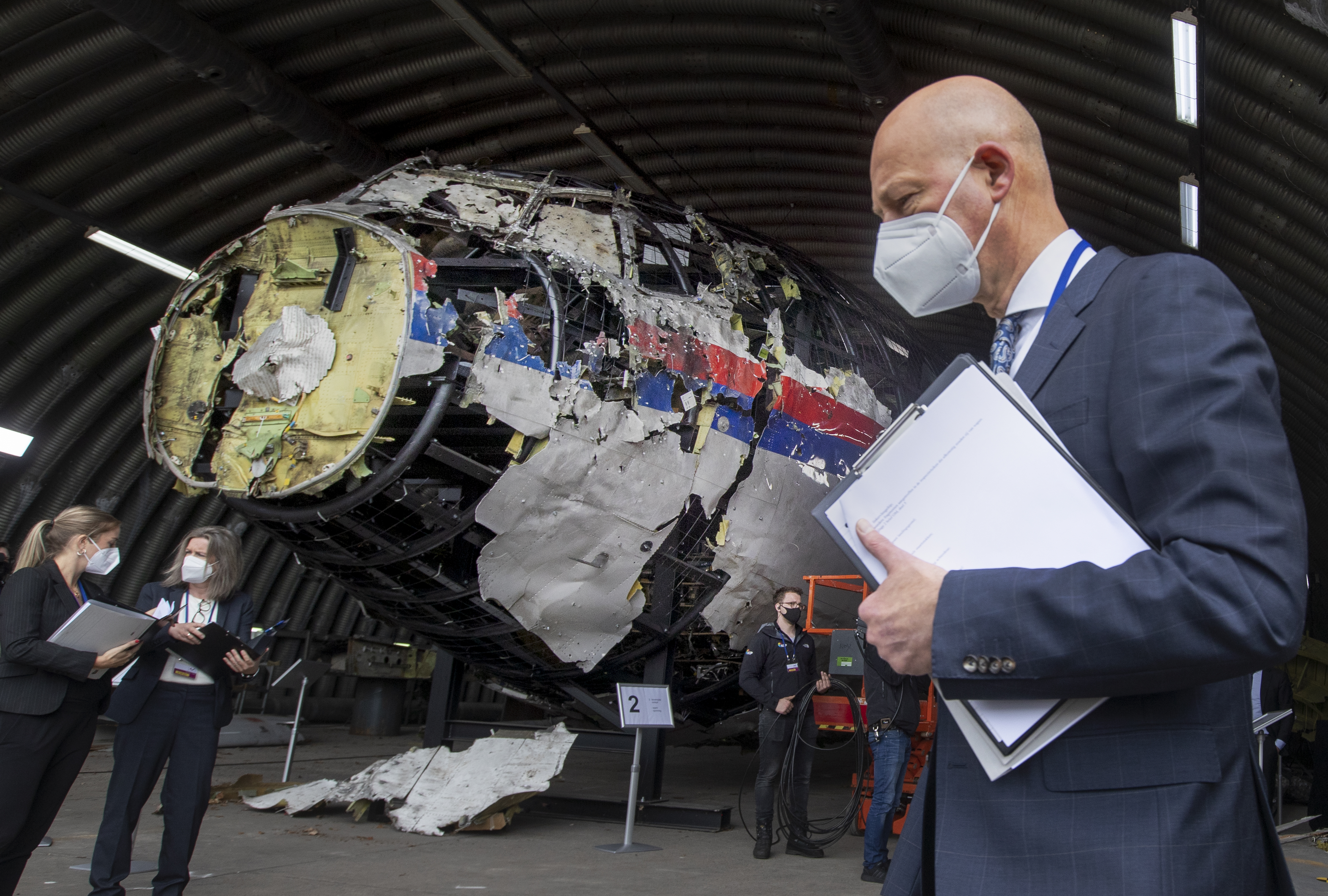 Presiding judge Hendrik Steenhuis, right, and other trial judges and lawyers view the reconstructed wreckage of Malaysia Airlines Flight MH17