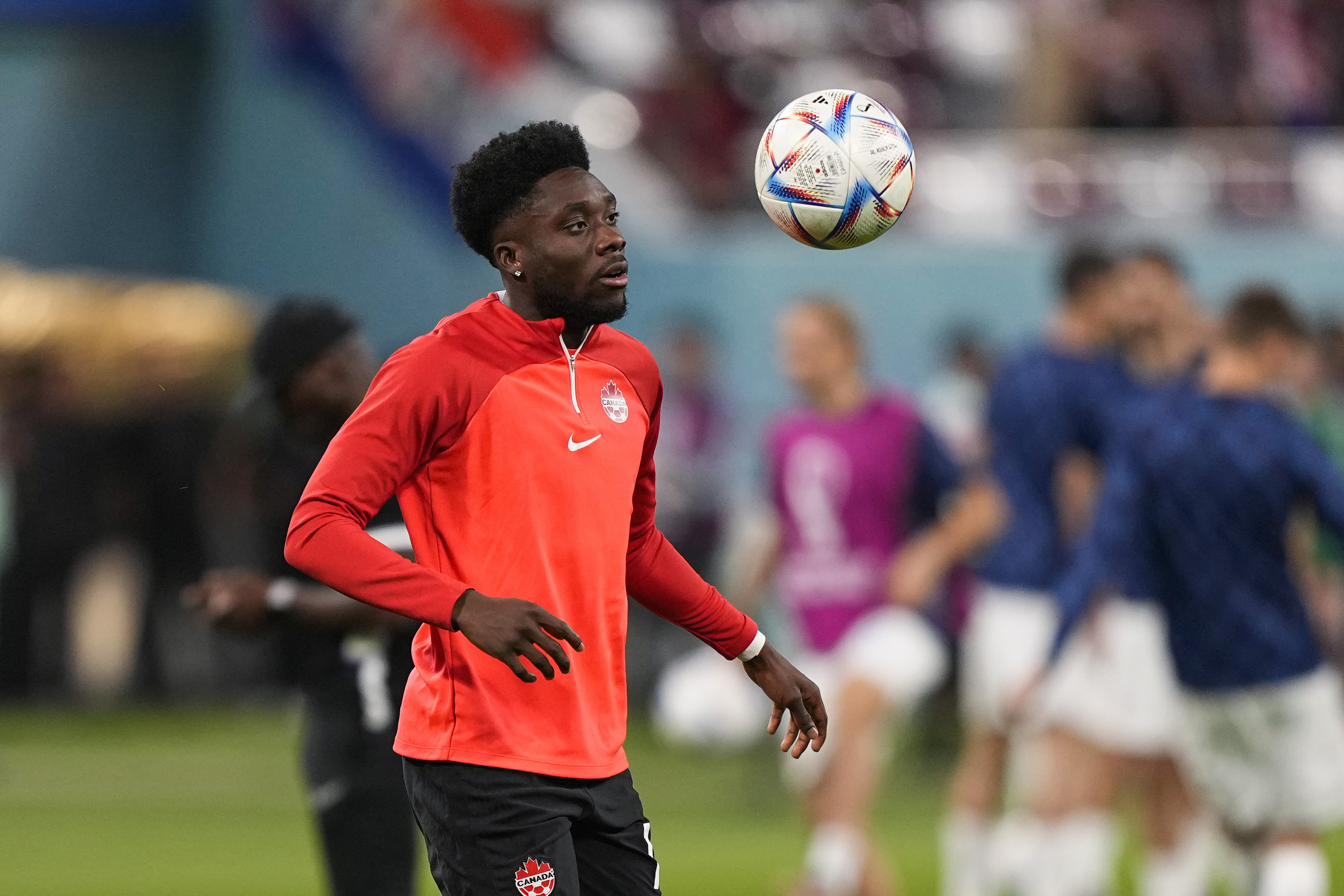 Canada's Alphonso Davies eyes the ball during a warm up session prior the World Cup group F soccer match between Croatia and Canada, at the Khalifa International Stadium in Doha, Qatar, Sunday, Nov. 27, 2022. (AP Photo/Martin Meissner)