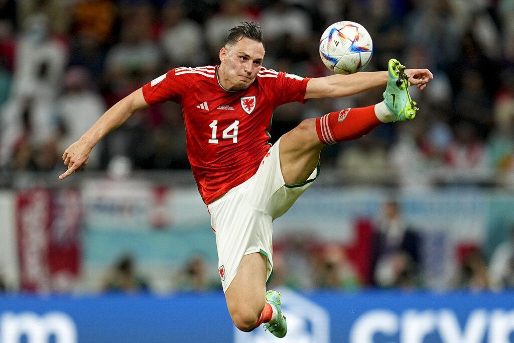 Roberts with a strained face is in mid-leap with his left leg right up near the ball and the right bent behind him