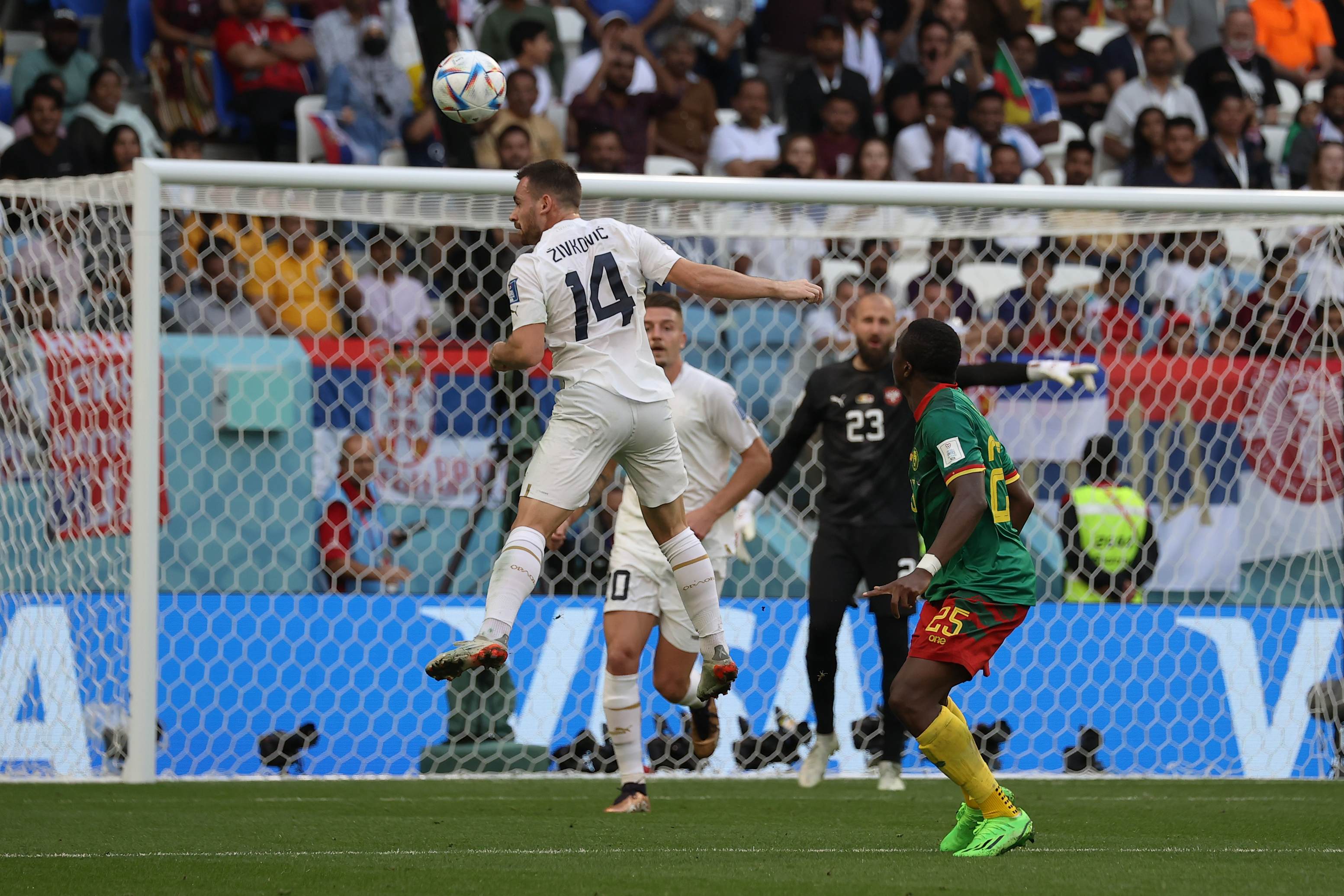 A Serbian player heads the ball.