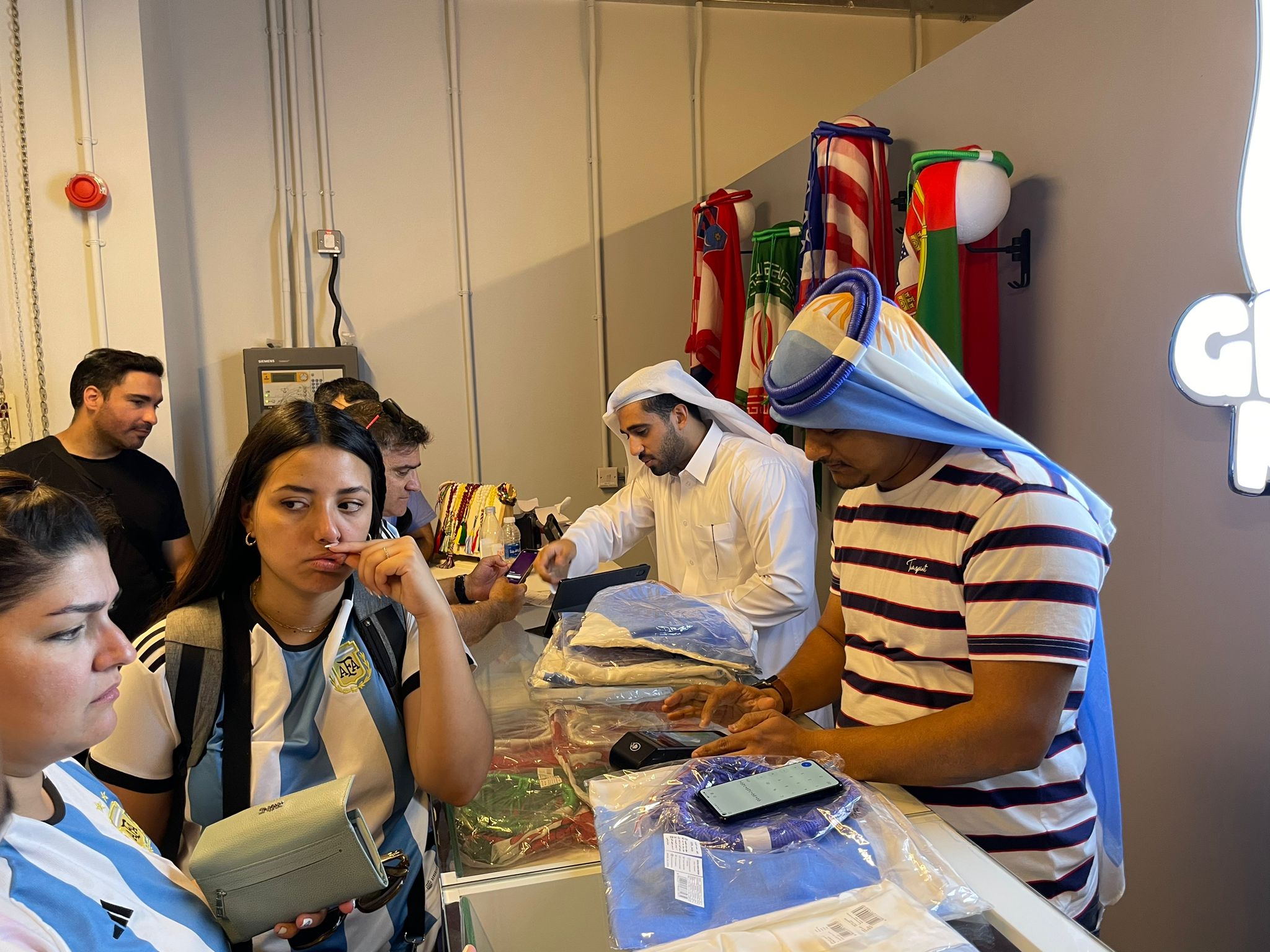 Argentine fans wait to buy sports accessories at the Ghutra Mundo store in Doha