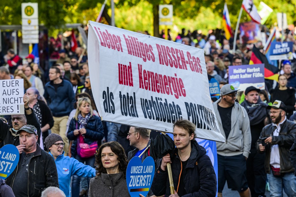 A protester holds up a sign reading: "I'd rather have cheap Russian gas and nuclear energy than completely stupid politicians" during a rally of far-right groups including the Alternative for Germany (AfD) party against rising prices in Berlin