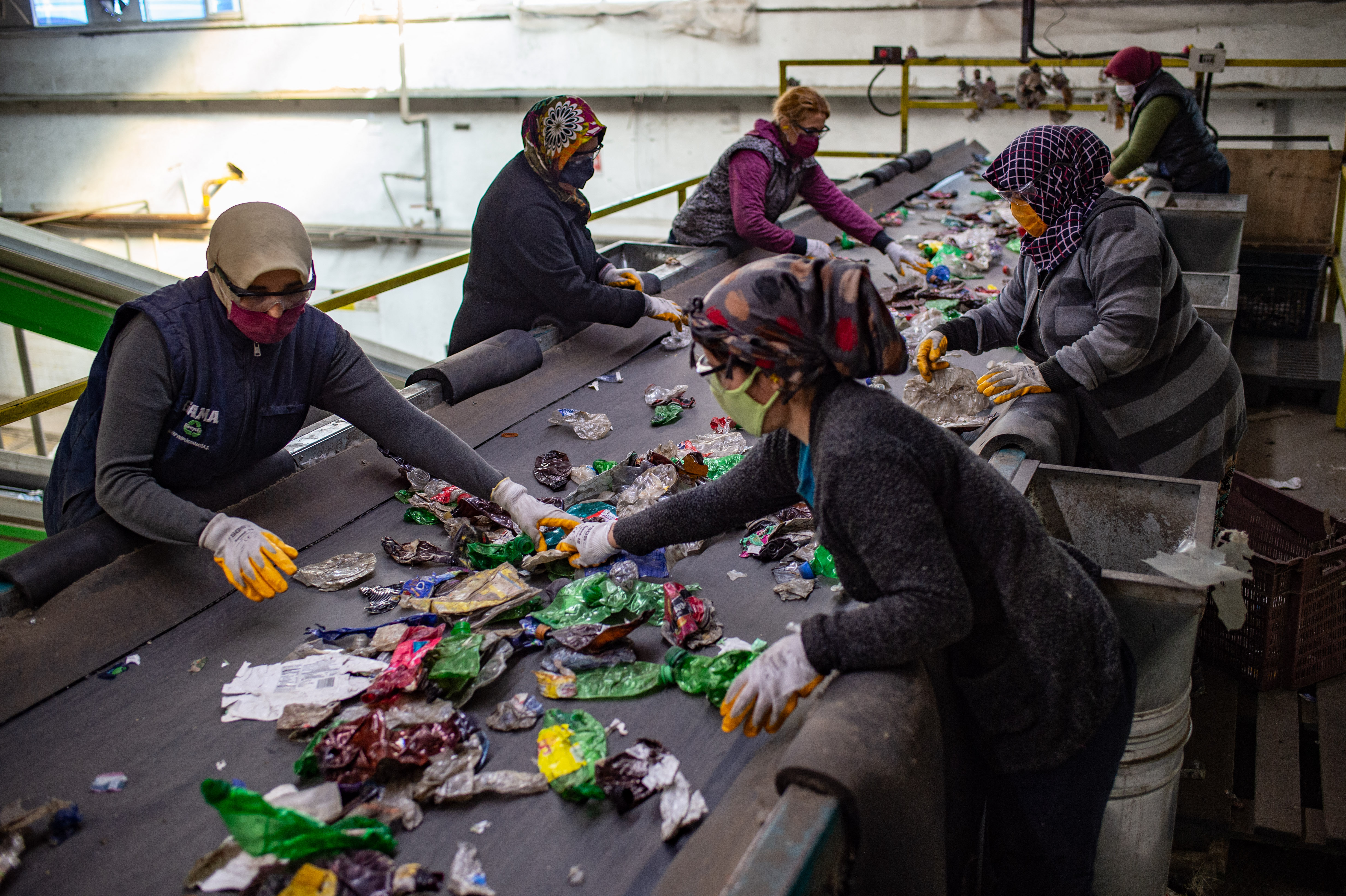 Employees work on November 28, 2020 at GAMA Recycle factory in the southern Turkish province of Gaziantep. - It is supposed to be recycled but instead plastic packaging from popular British supermarkets like Sainsbury's and French frozen food retailer Picard is ending up being dumped illegally in the Turkish countryside. There are at least 10 known sites in southern Turkey where European plastics have been dumped illegally. (Photo by Yasin AKGUL / AFP)