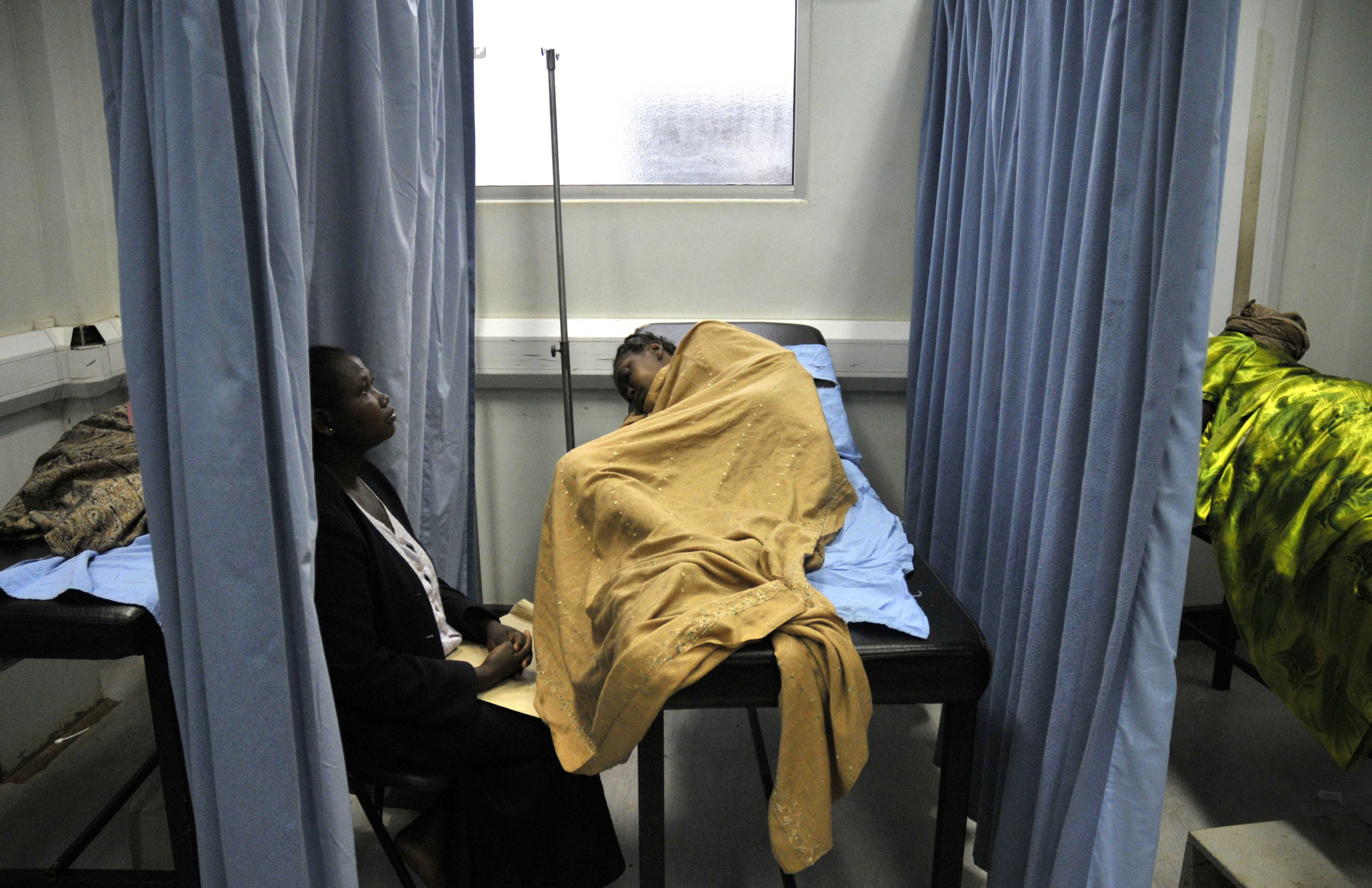 An attendant cares for a patient infected with HIV/AIDS in a ward in Uganda's Infectious Disease Institute