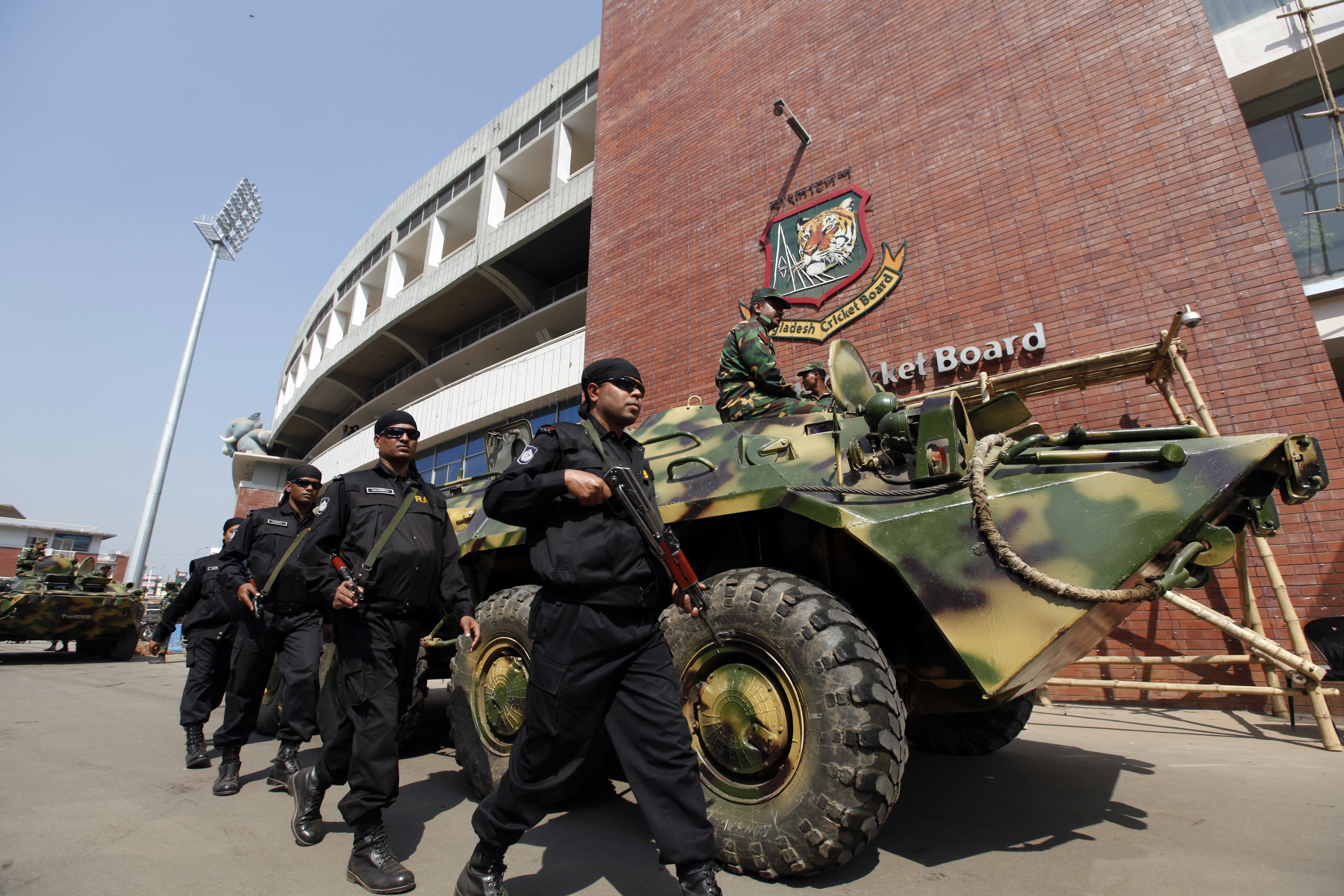 RAB members walk next to an armoured personnel carrier