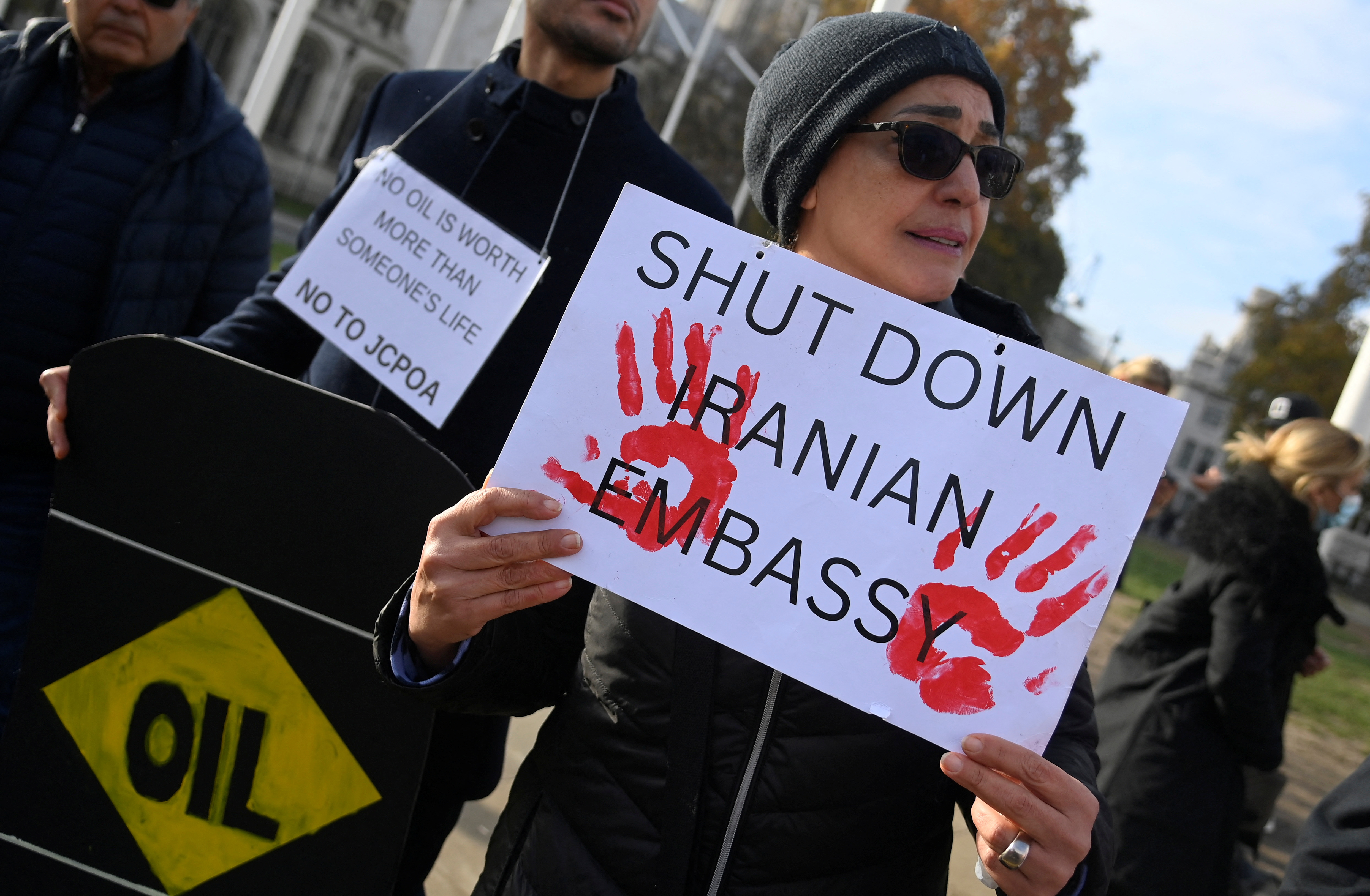 Protester holding a banner saying 'Shut Down Iranian Embassy'
