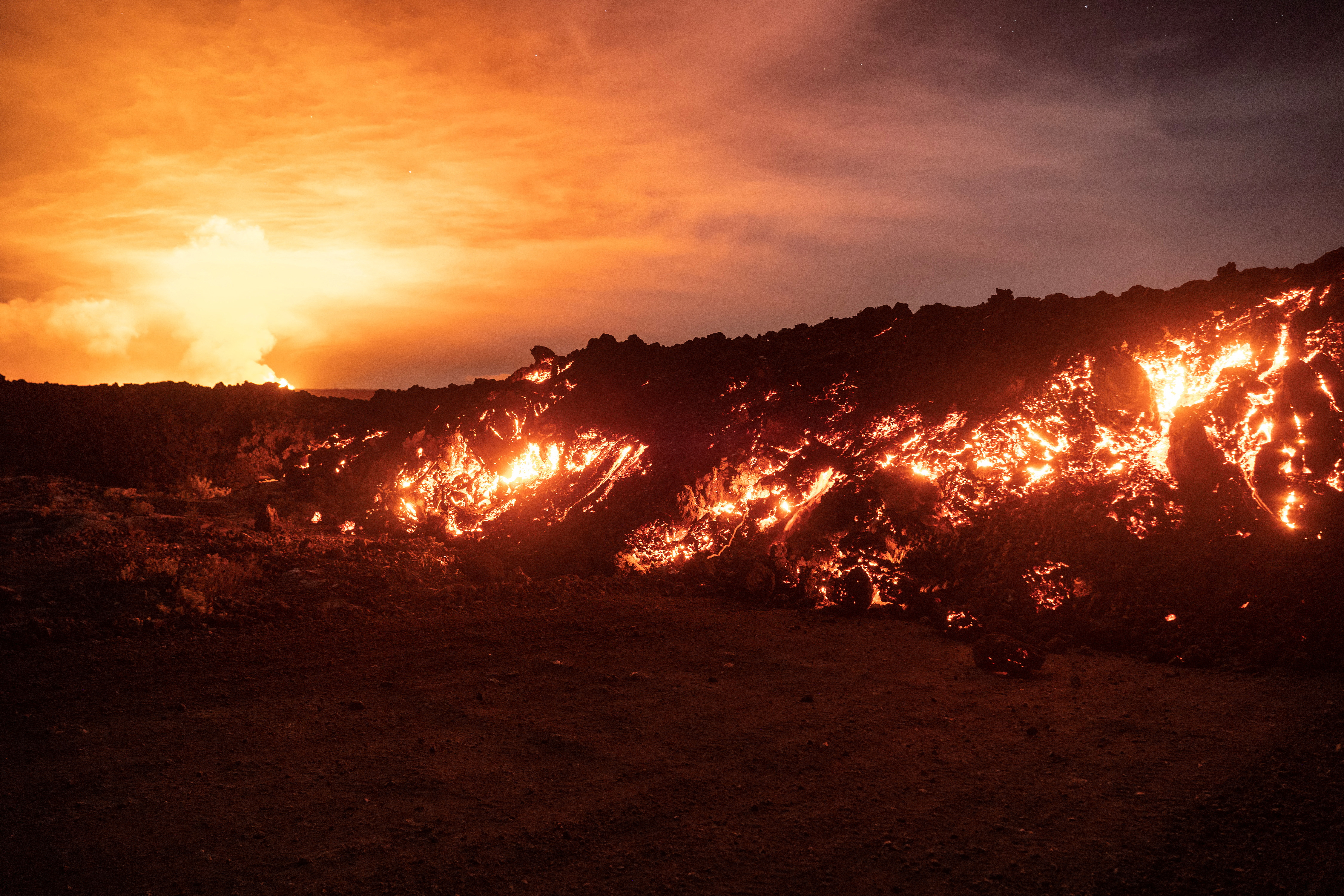 Lava fountains and flows illuminate the area during the Mauna