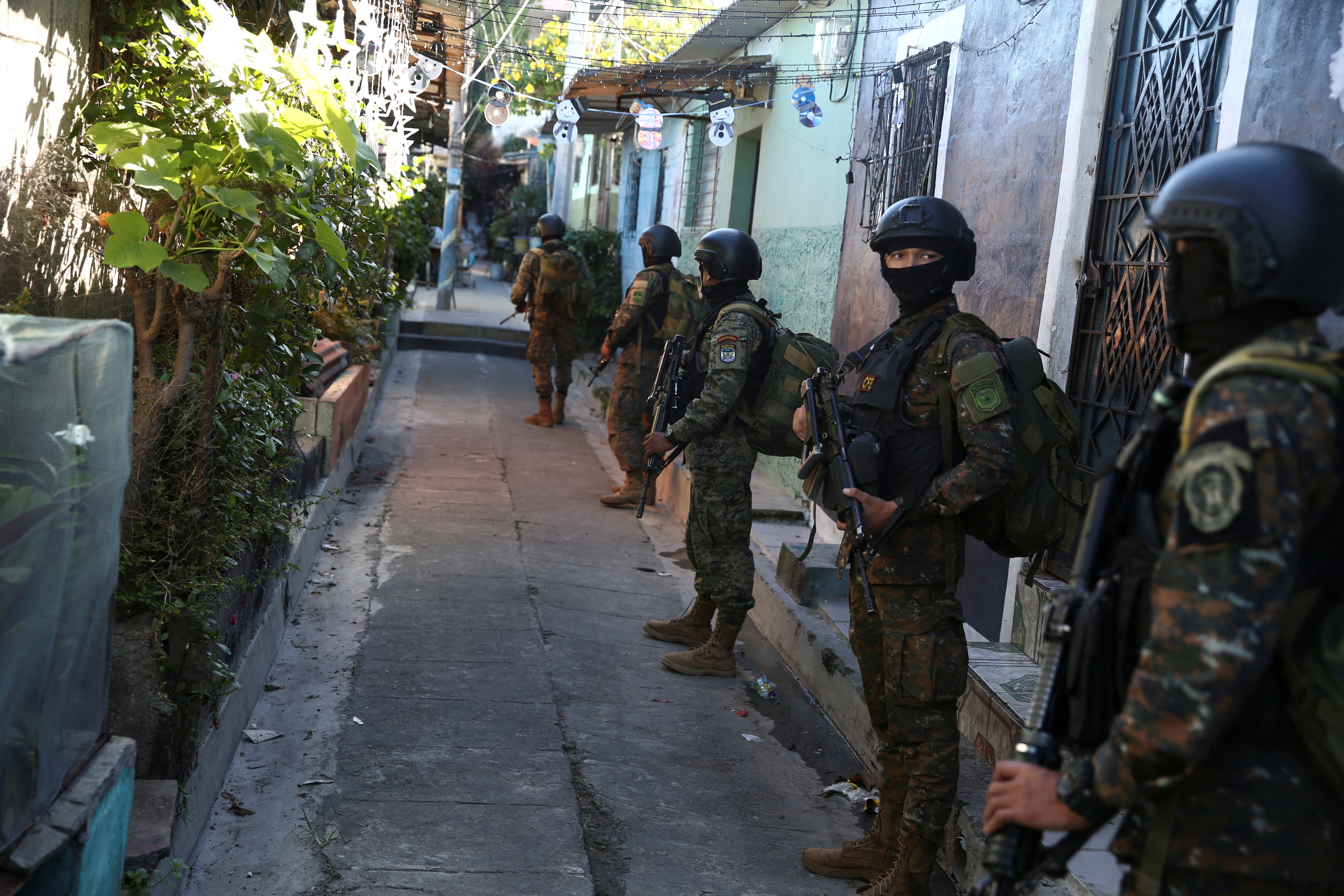 Soldiers stand in an alley