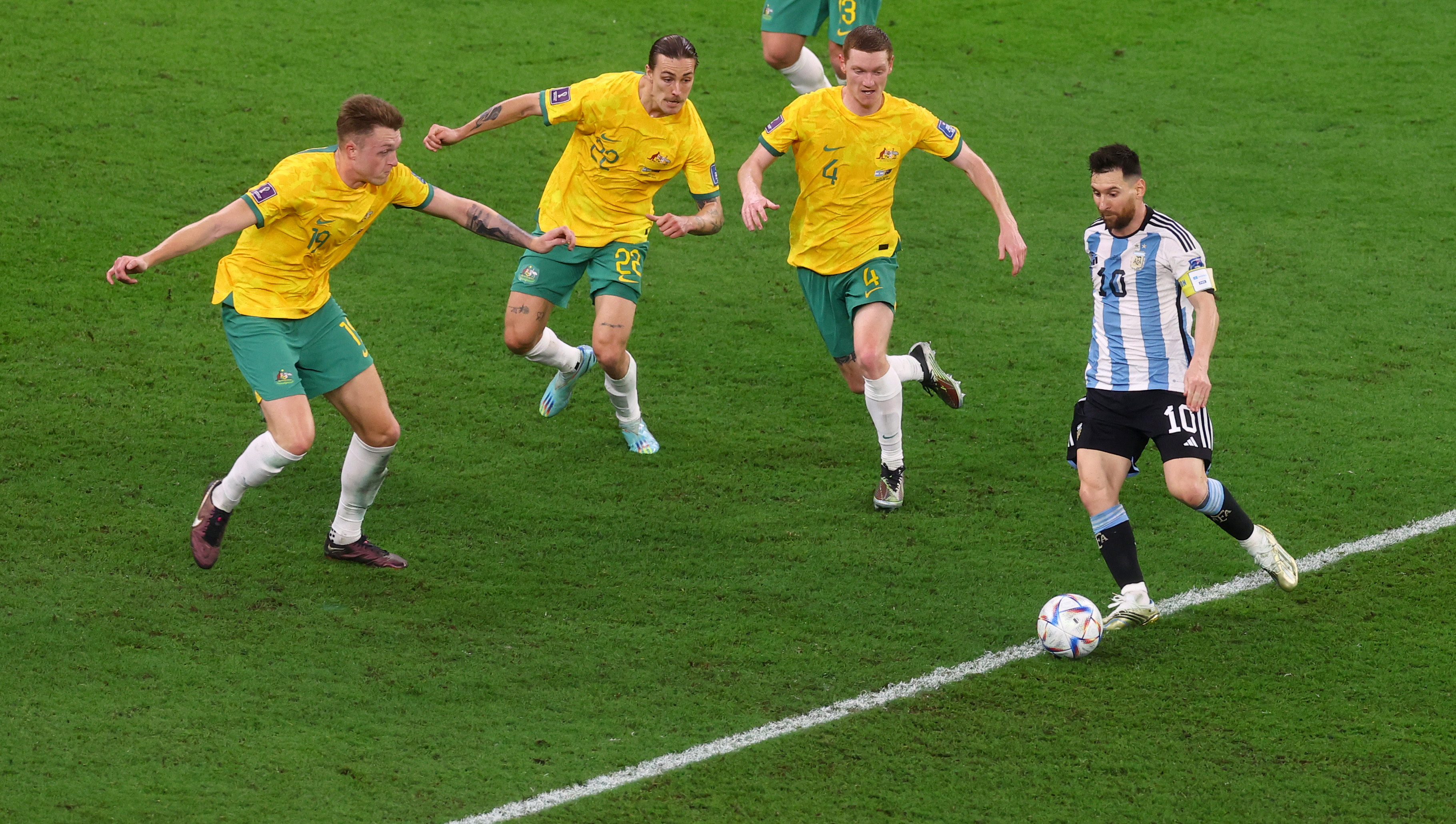 Lionel Messi with the ball against three Aussie defenders.